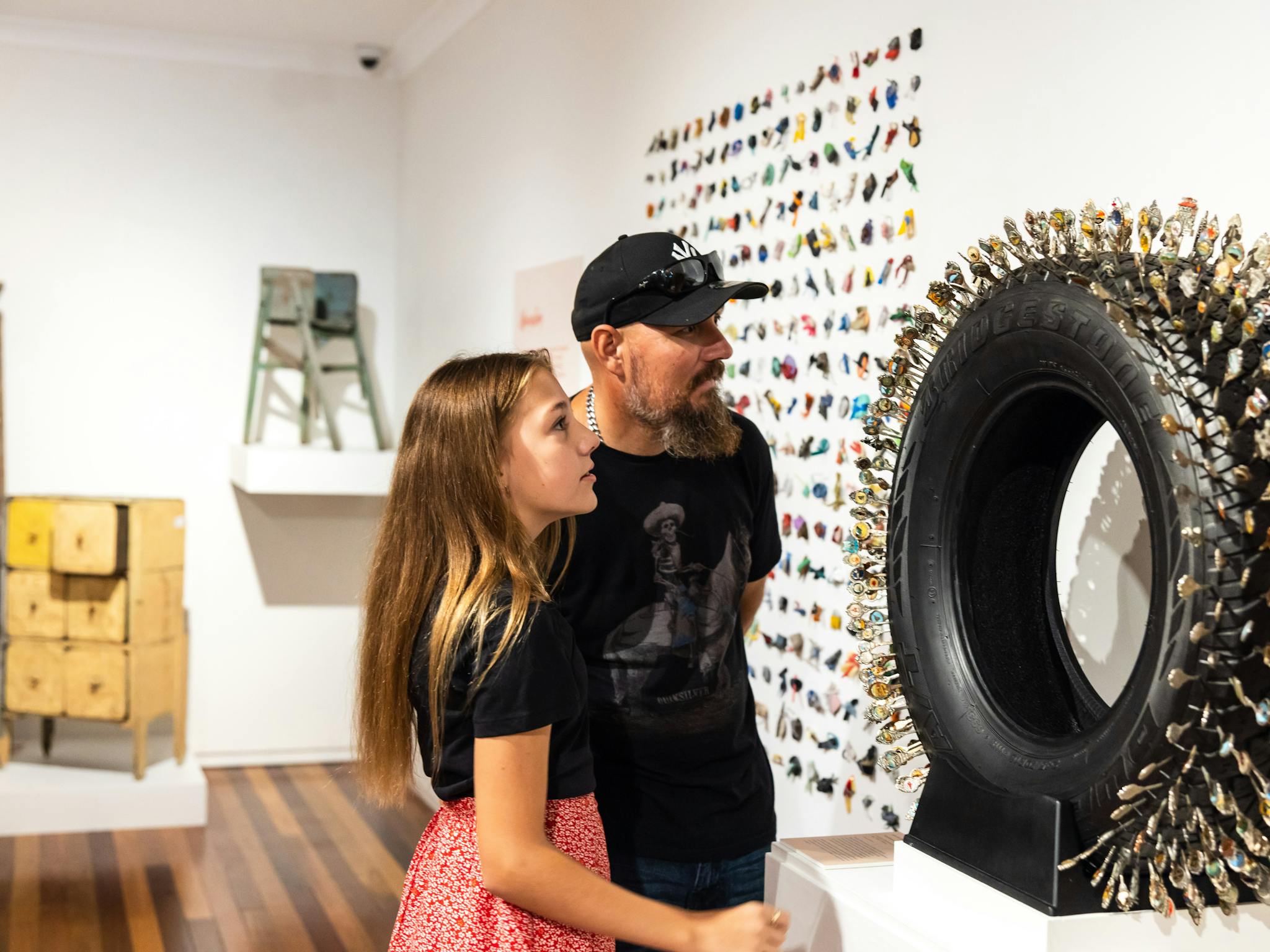 Lady and man looking at a wall-mounted exhibition item Lady and man looking at a wall-mounted exhibition item