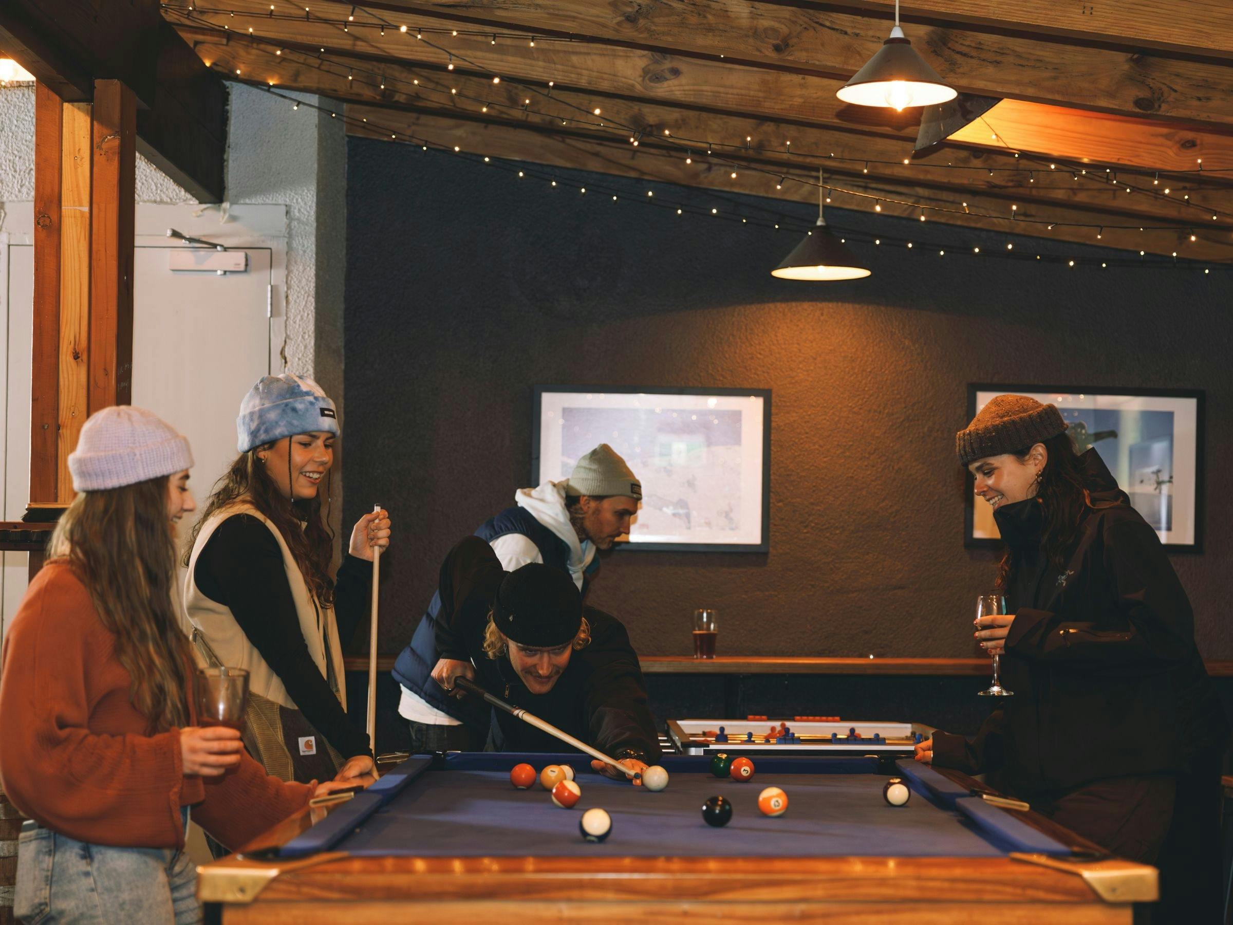 A group of friends enjoying drinks and games at Frying Pan Inn including pool, foosball and darts