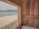 Interior view shot of Finnish style cedar sauna with view of nature and lake on a cloudy day