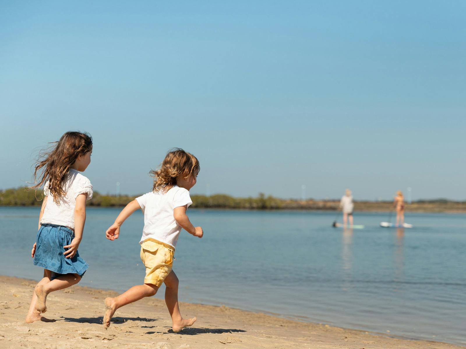 Two young children running into the water