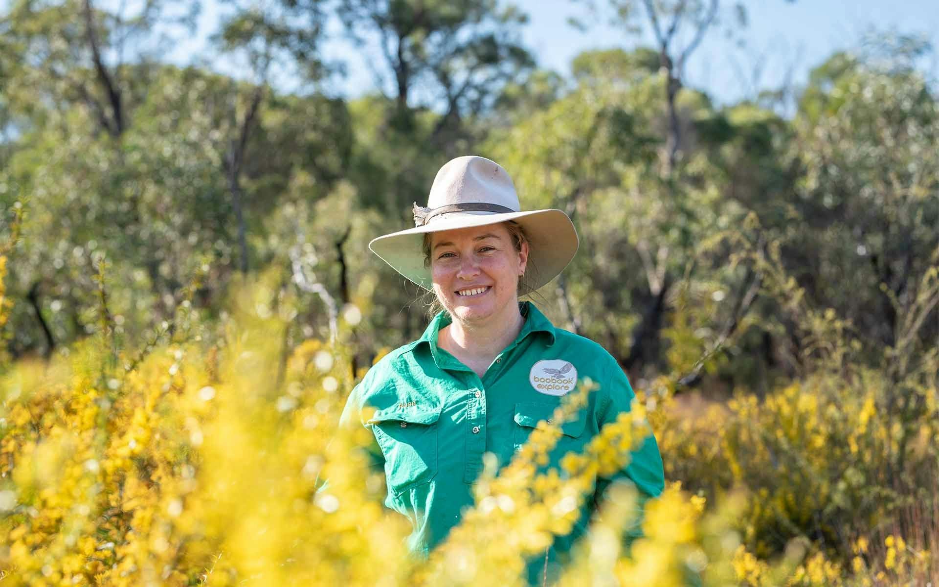 Botanist guide standing behind a yellow wildflower bush