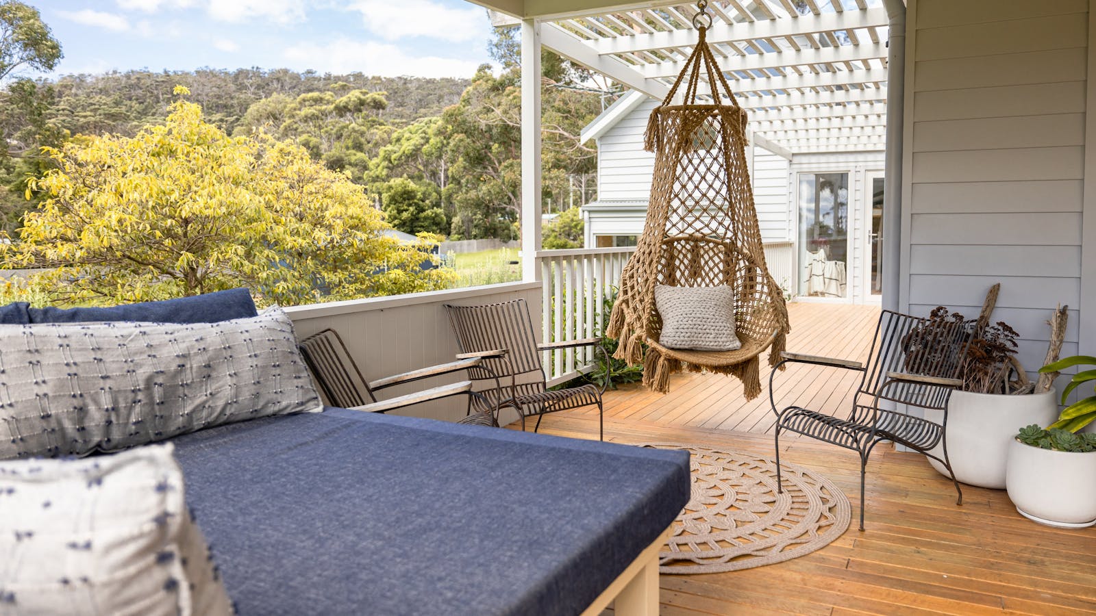 Deck overlooking the water with day bed and swing.