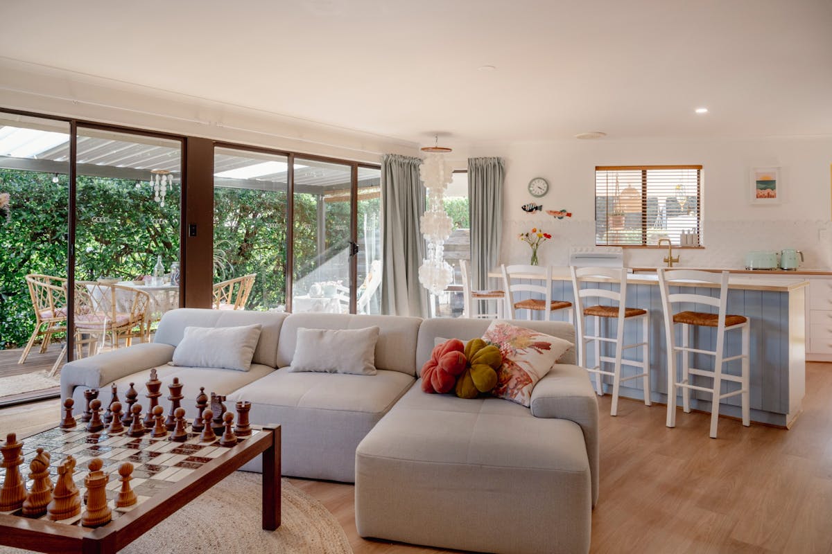 Living room - includes large 3 seater sofa, daybed, chess table, games cupboard, and TV