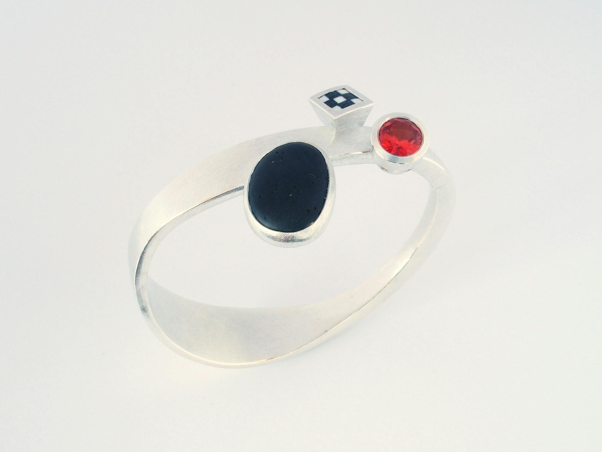 Hand forged silver bangle by Marcus Foley set with pebble porcelain and synthetic sapphire.