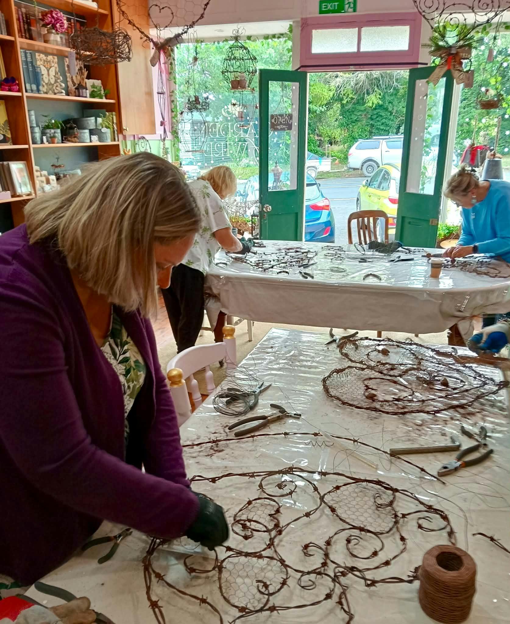 Guests around the work tables inside the workshop making their Hearts of Wire creations
