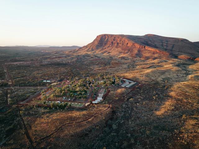 An aerial photo shows Tom Price Tourist Park nestled next to Mount Nameless in the Pilbara