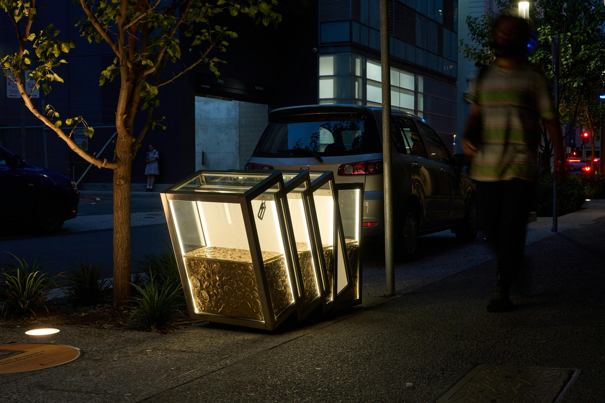 Rolling transparent boxes lit from within filled with golden objects like coins