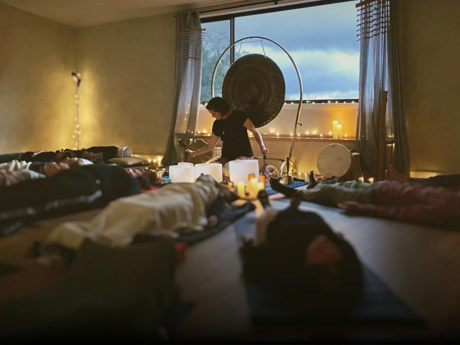 Photo of Natalie Grace playing singing bowls during a sound bath