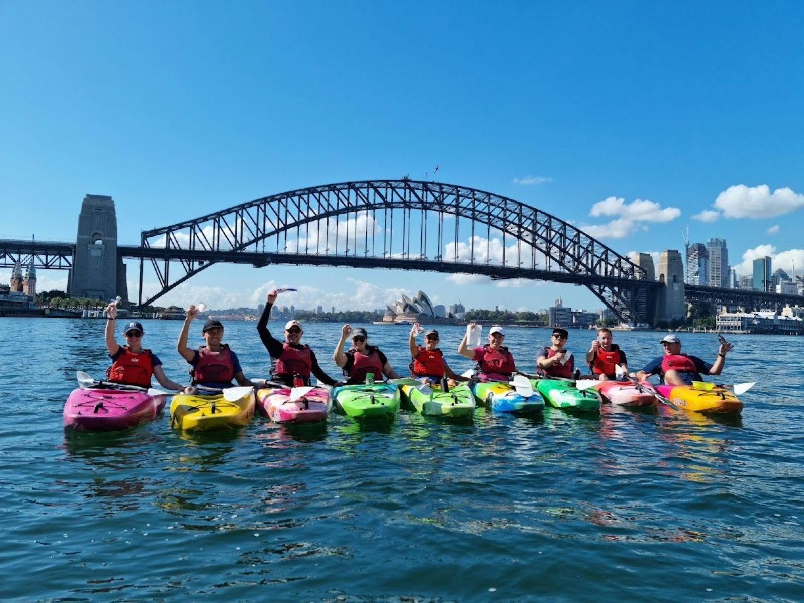 Farbenfrohe Kajakfahrer im Hafen von Sydney.