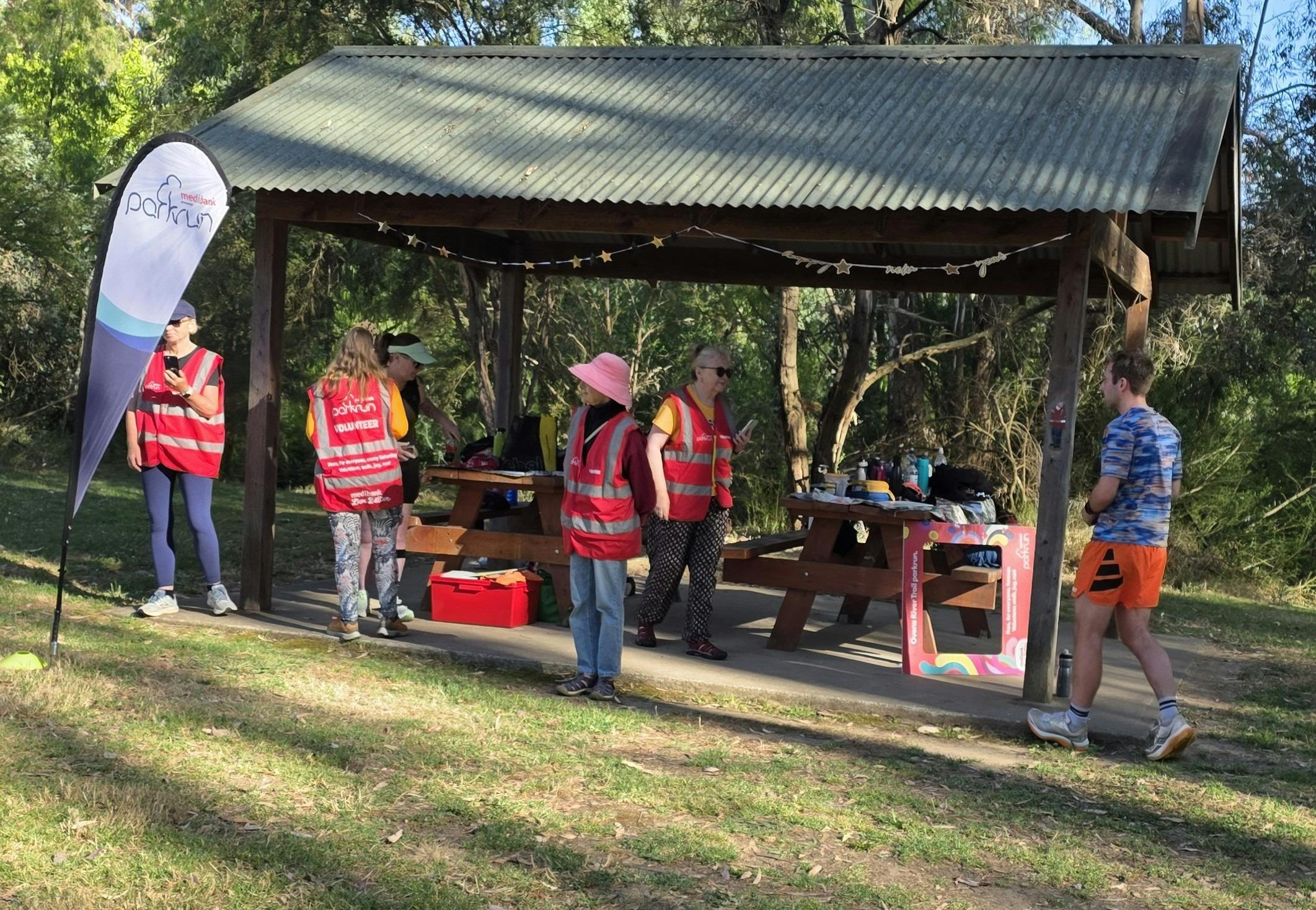 5 volunteers standing at the finish waiting for participants