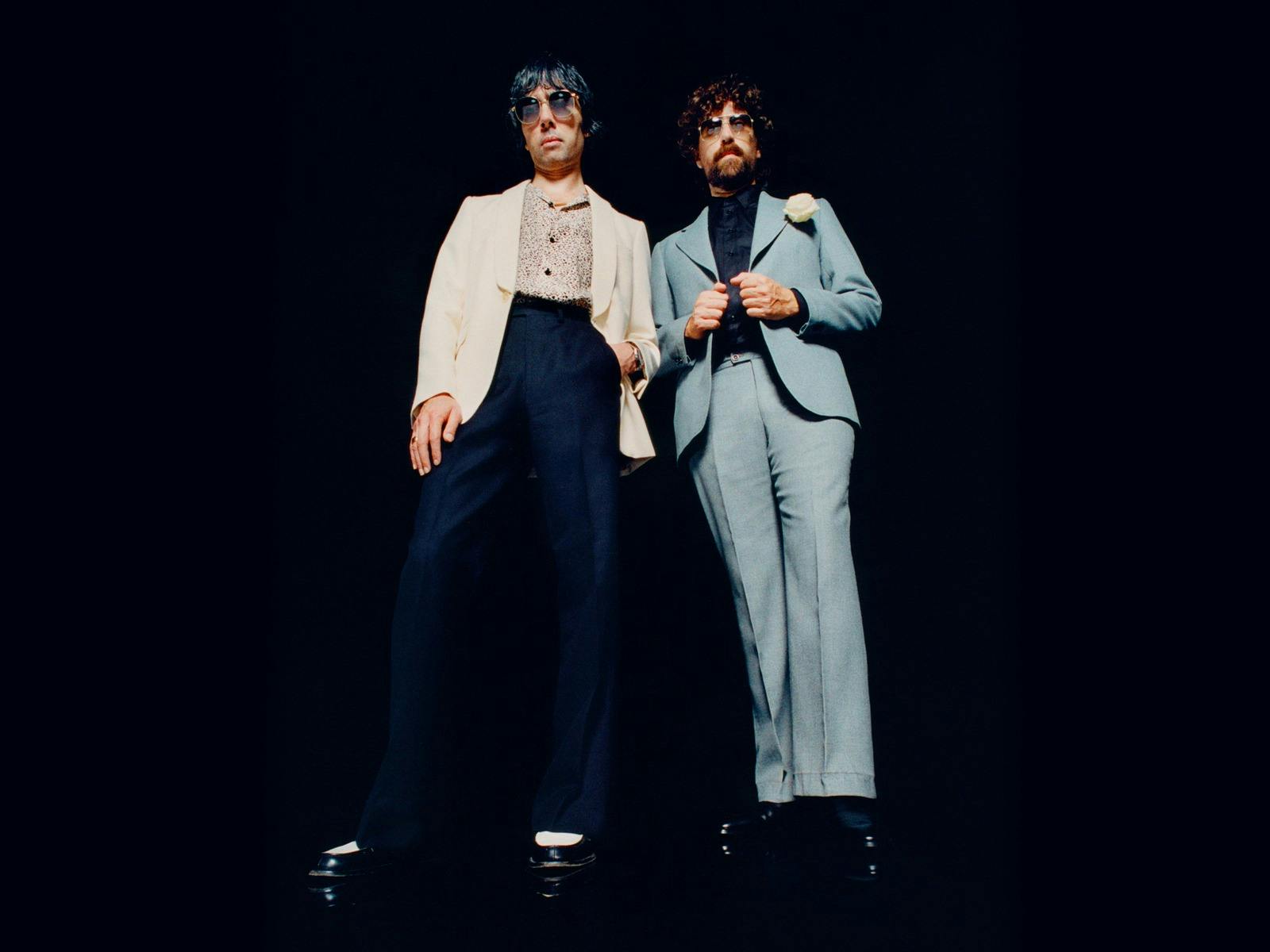 Justice artists standing together in formal attire. Black background