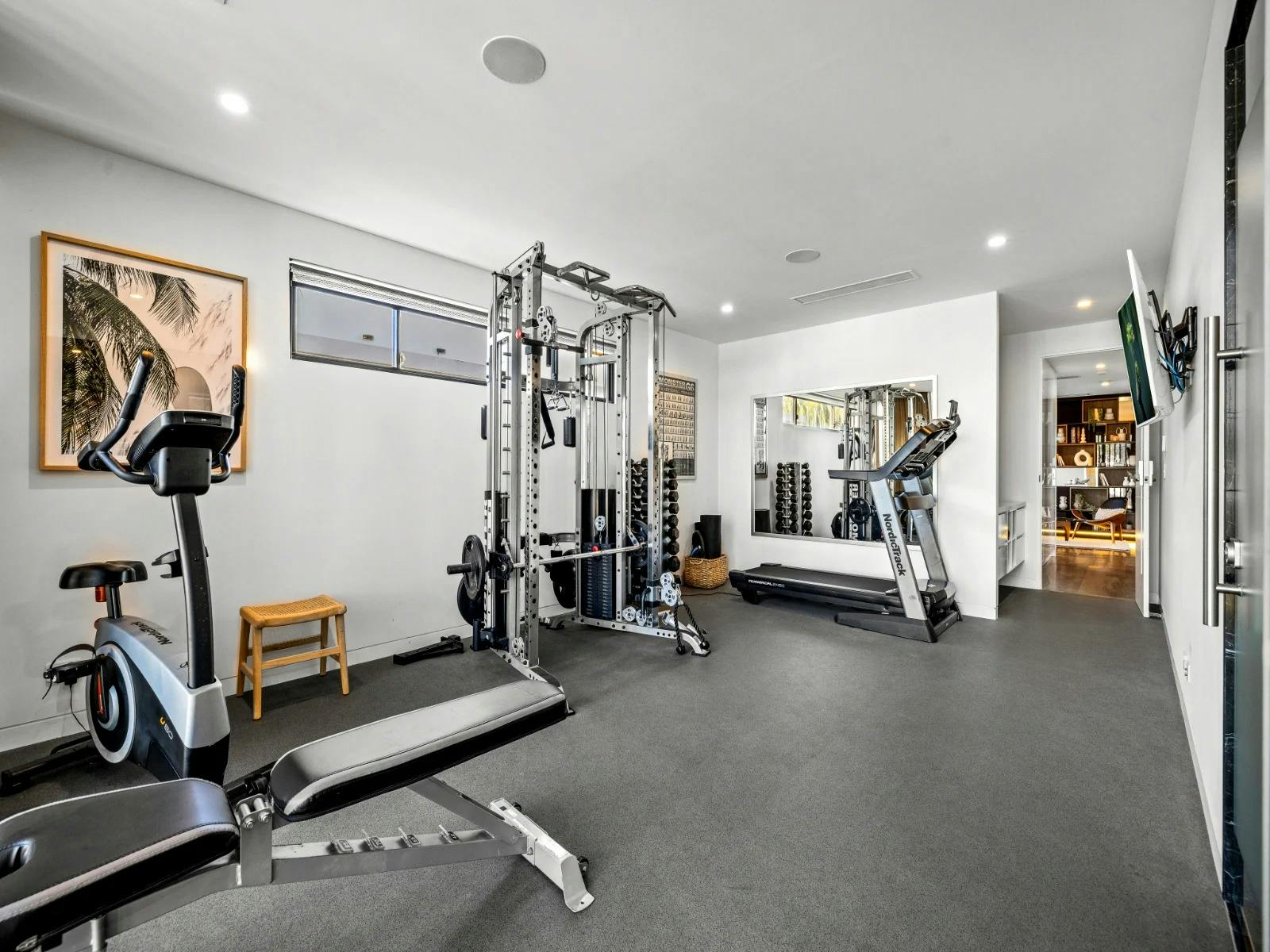 Private gym with cross trainer, treadmill, TV, yoga mats, and weights