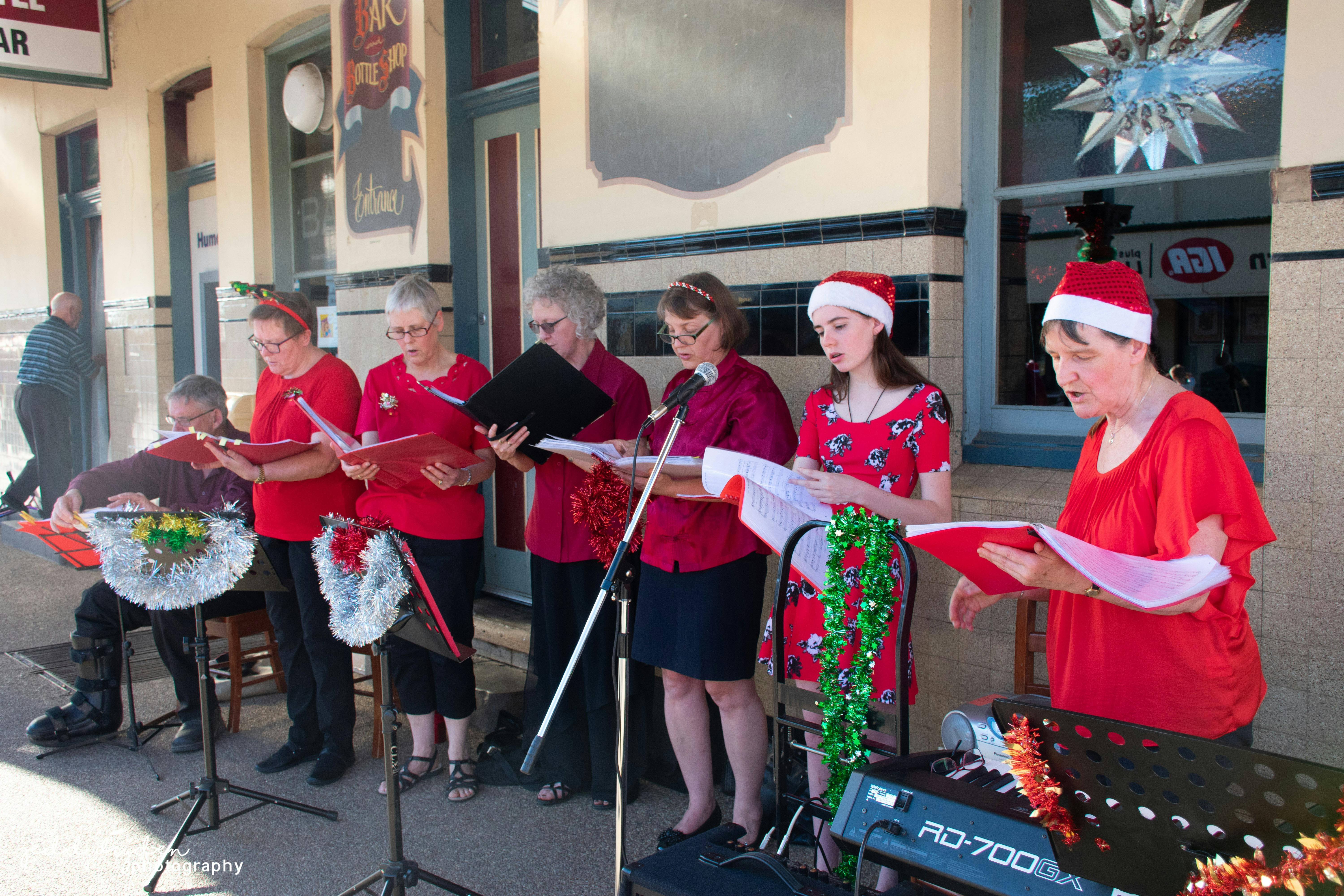 A group of carol singers leading folk in Christmas songs