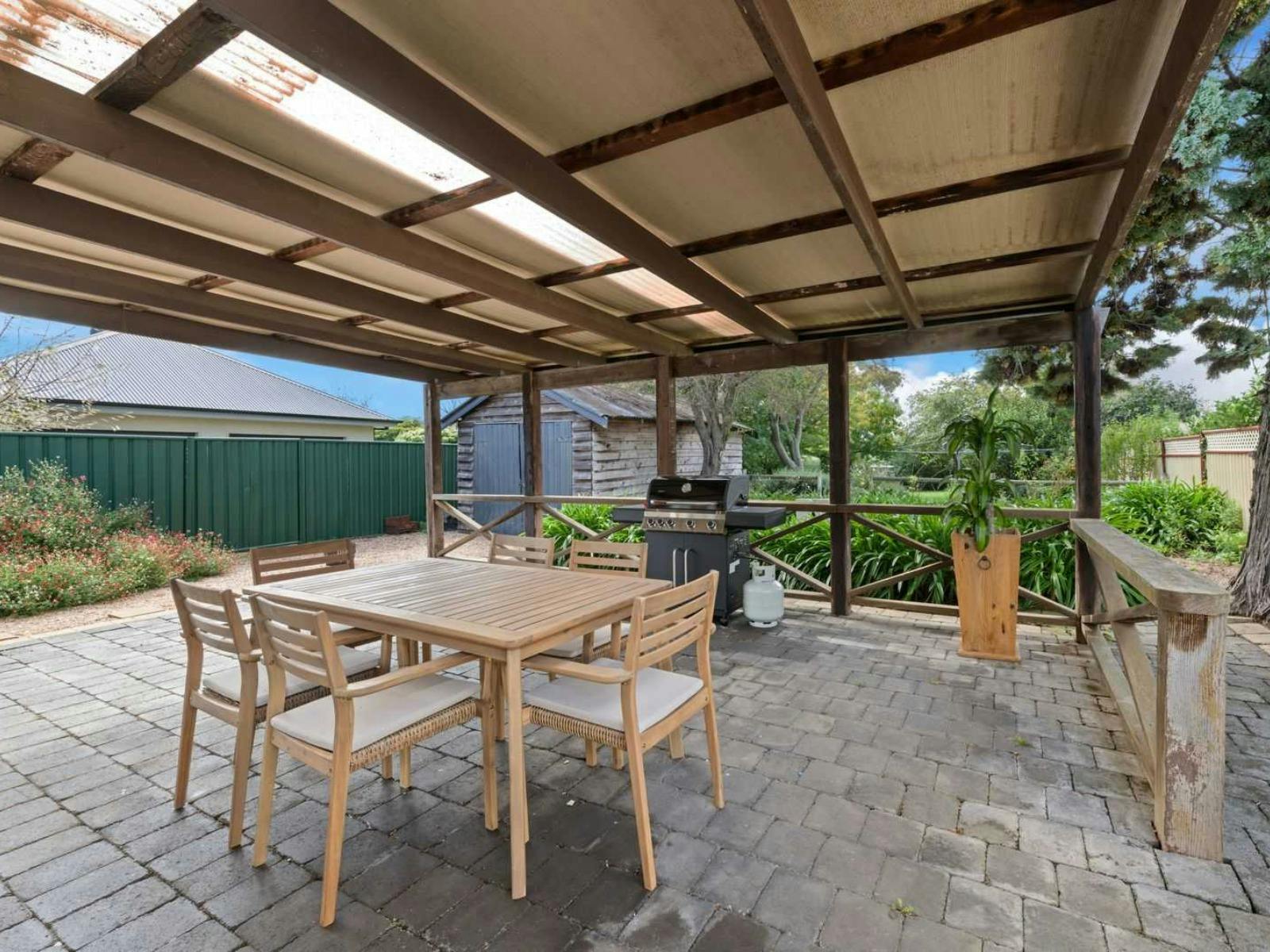 Outdoor dining table with undercover area, large green backyard