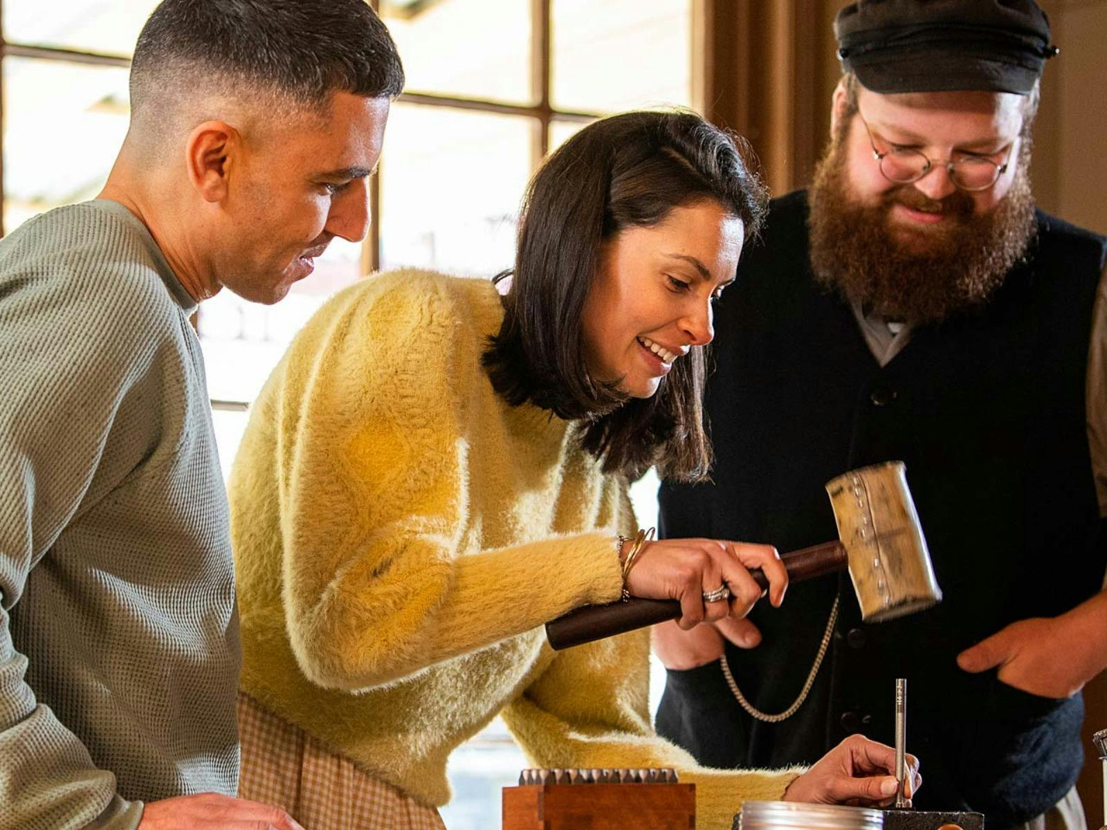 Man and woman making keyring with Sovereign Hill leather-maker inside workshop