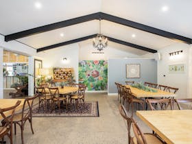 Indoor picture of our back room, showing tables & chairs and our feature wall.