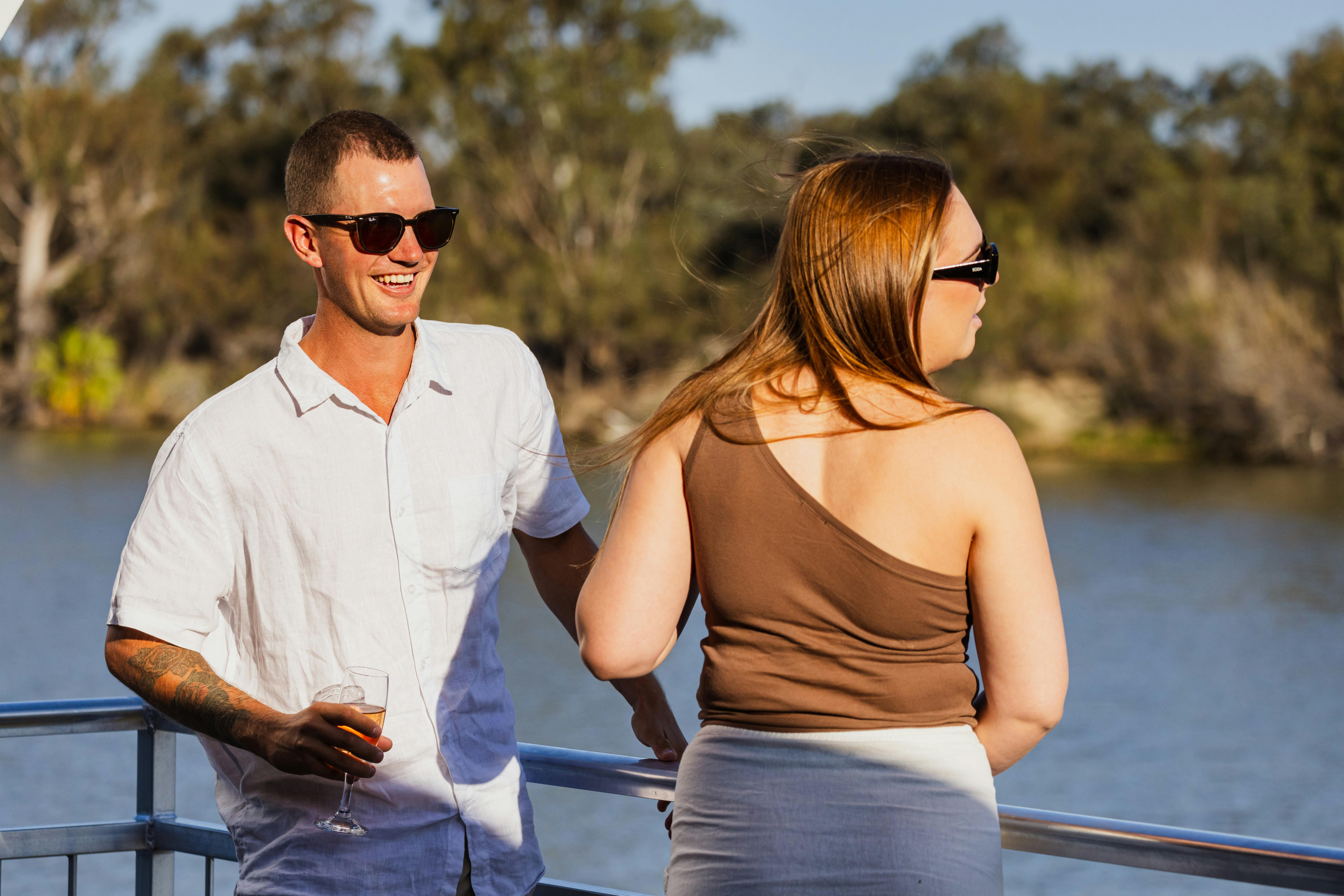 Couple cruising down river on Houseboat