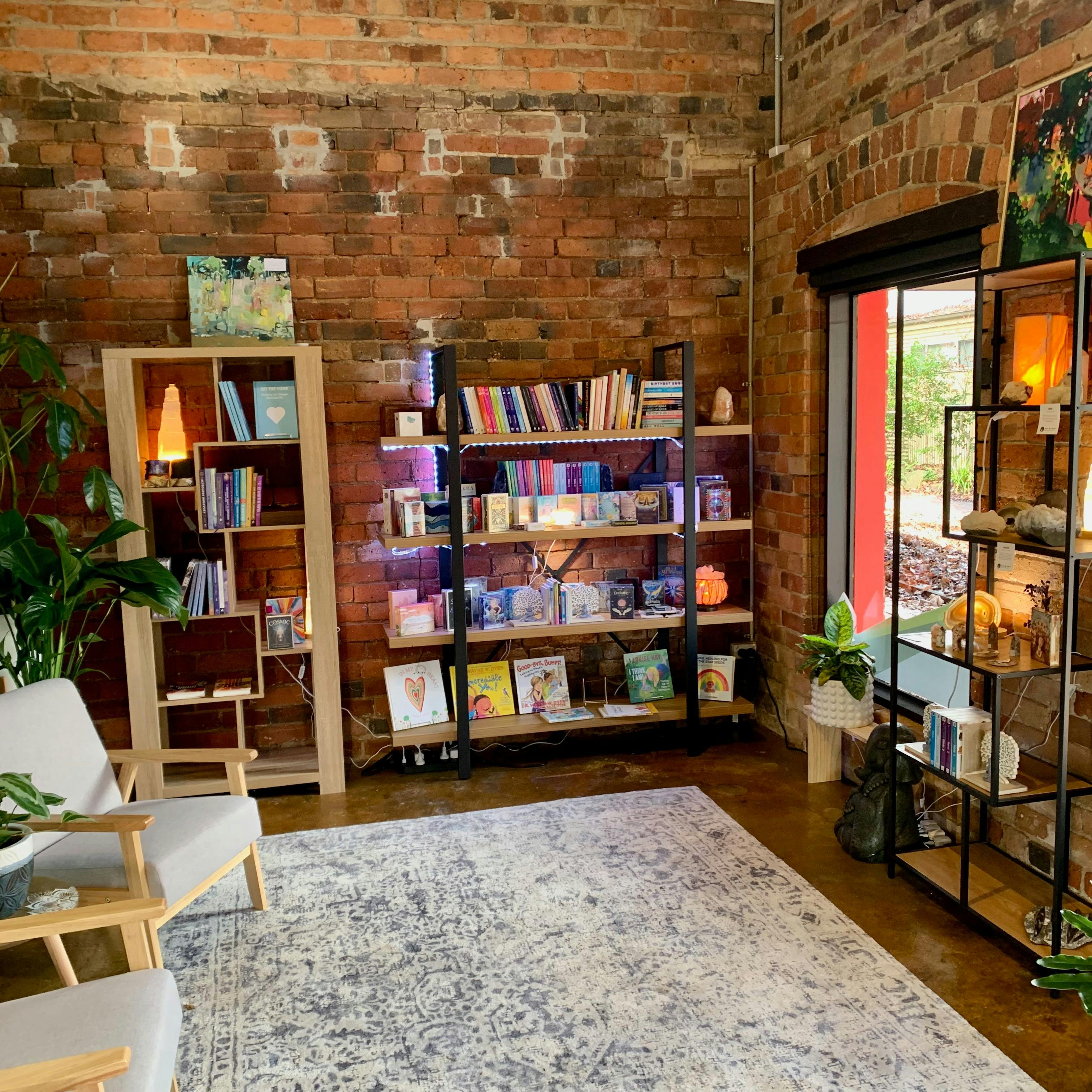 Photo of shelving diplaying books, oracles, lamnps and crystals.