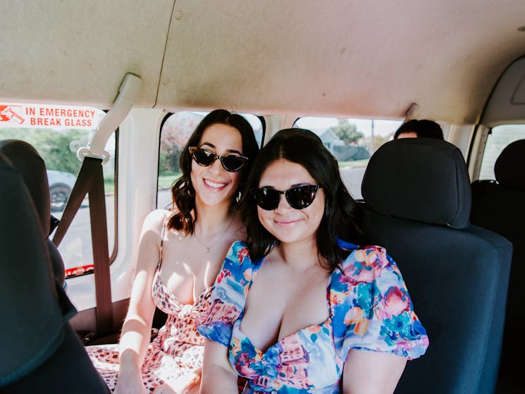 Two girls sitting inside tour bus