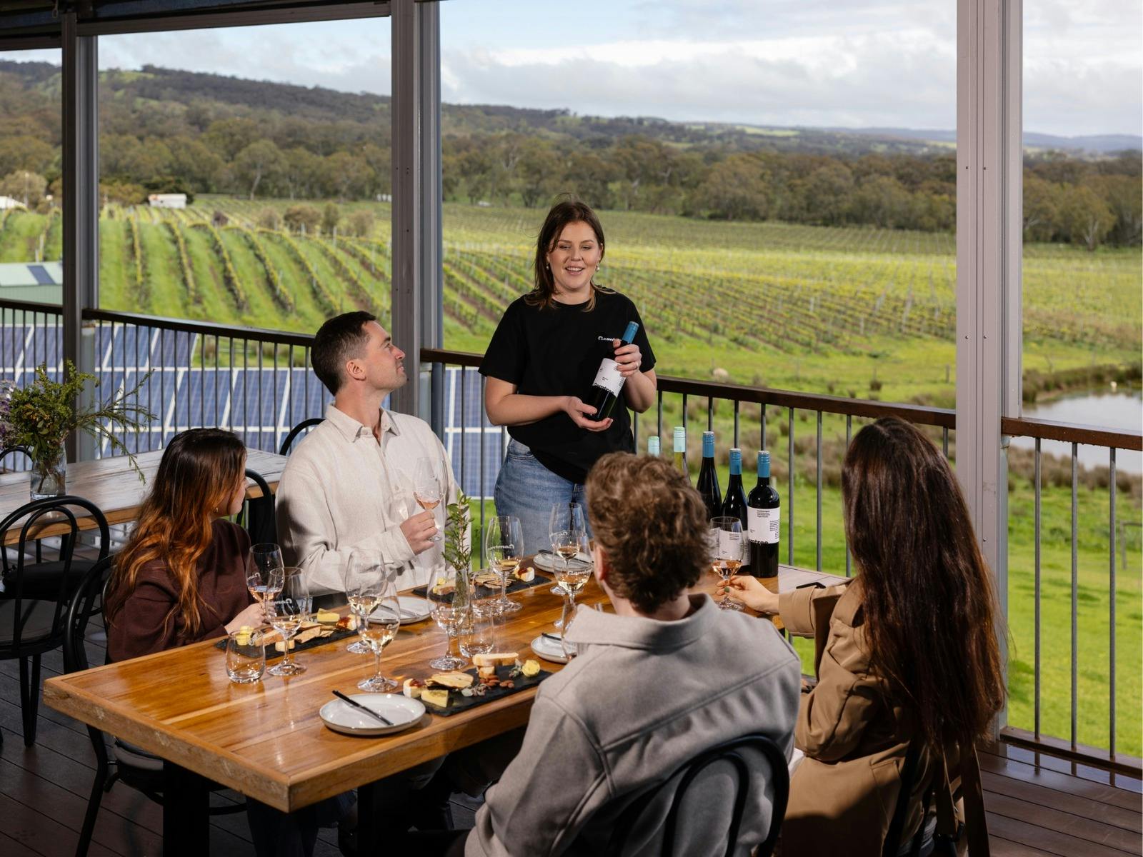 Gemtree staff member talking to four customers in a guided tasting on the deck