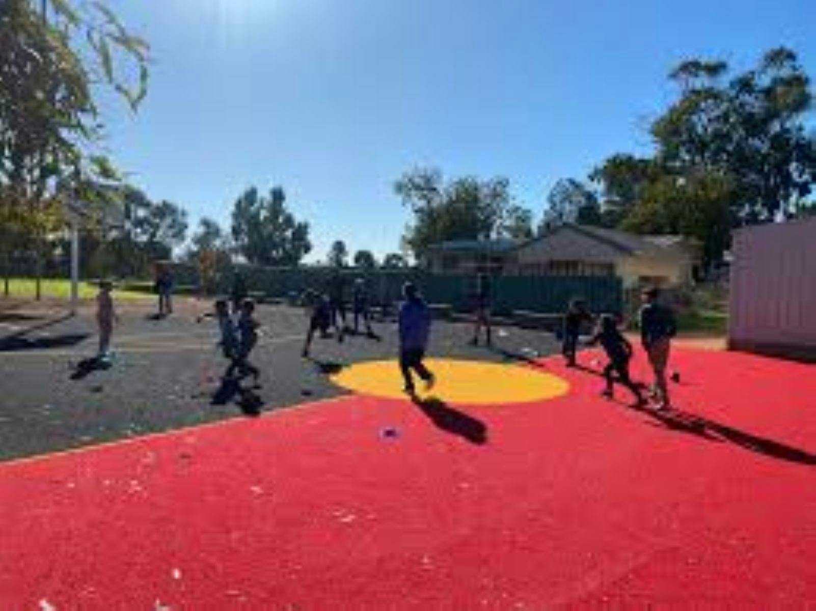 Image of Children playing on basketball court with image of flag