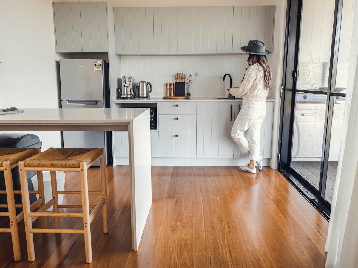 Breakfast bar with stools, kitchenette with lady preparing a drink