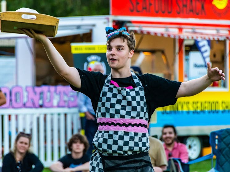 A young male donut seller walking through the crowds selling donuts at Borderville 2021.