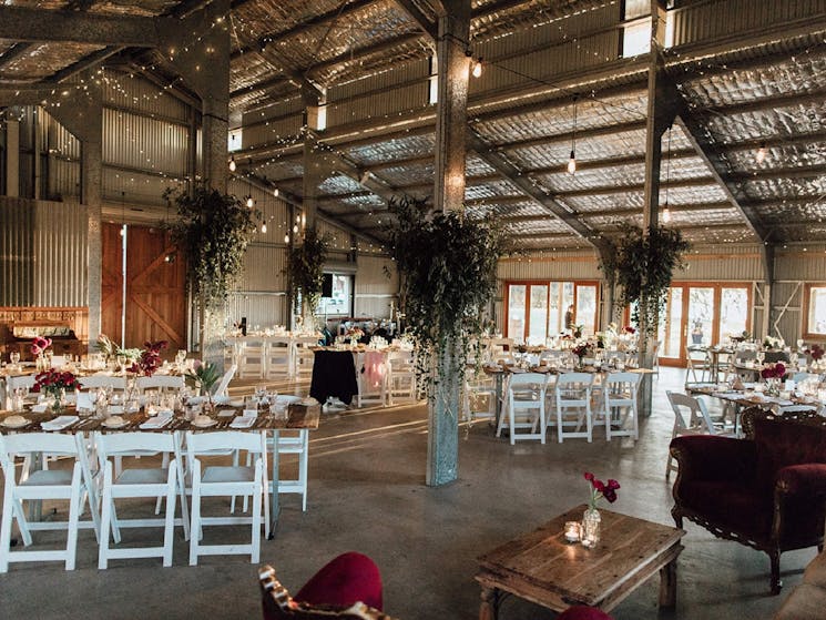 Large barn with decorations and set tables.