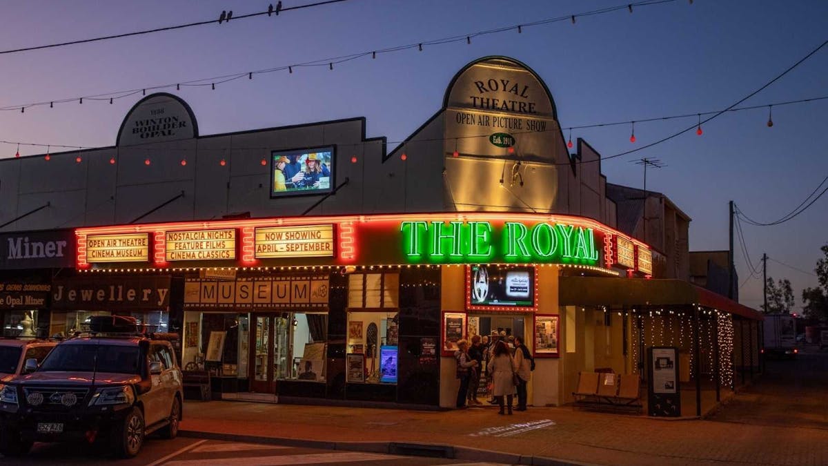 The Royal Theatre lit up at night with gallahs on the power lines and sunset.