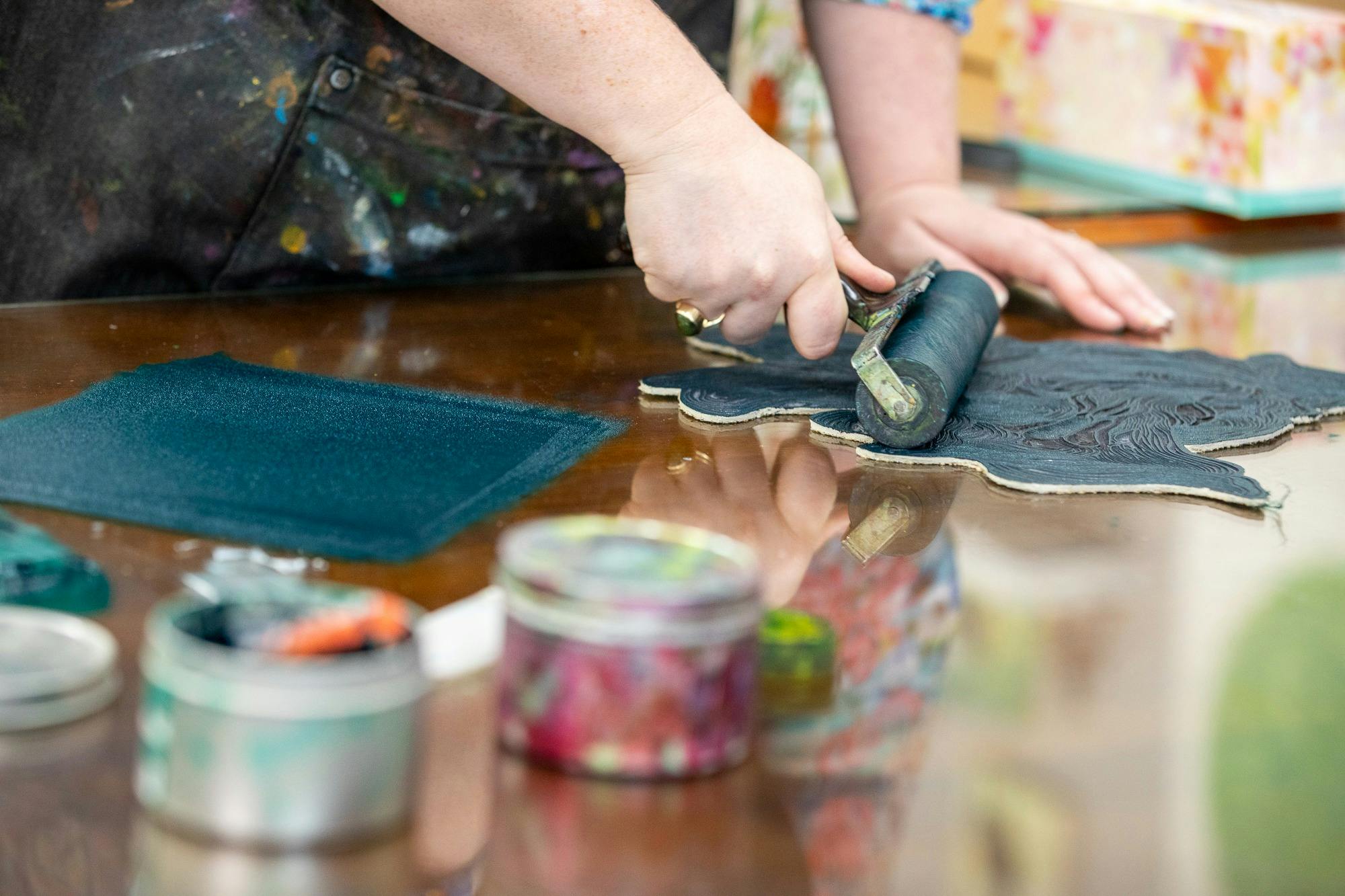artist rolling green ink with brayer