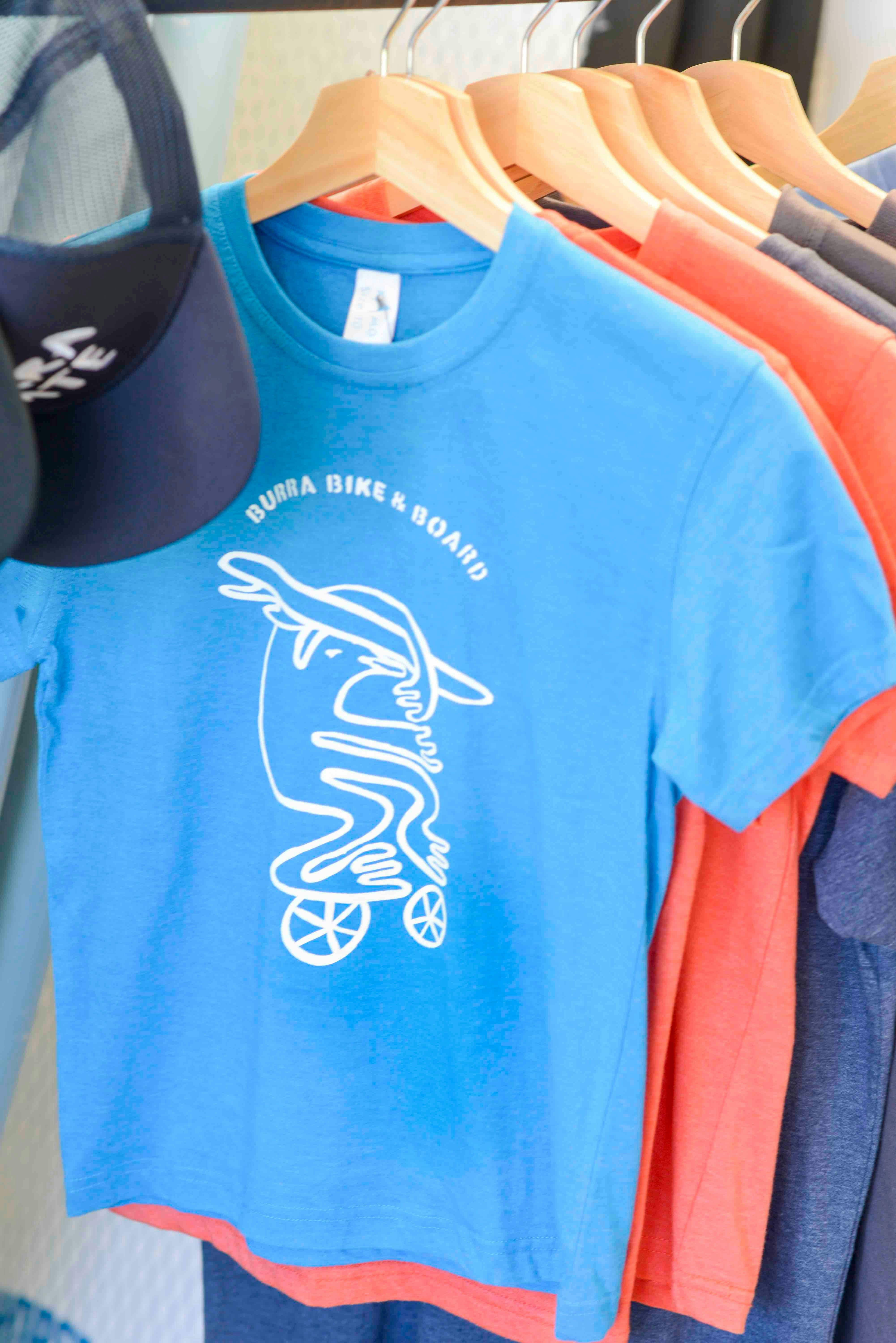 Blue tee shirt with original Burra bird surfing logo on front.