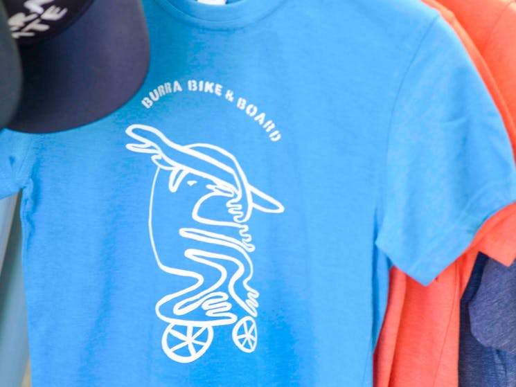 Blue tee shirt with original Burra bird surfing logo on front.