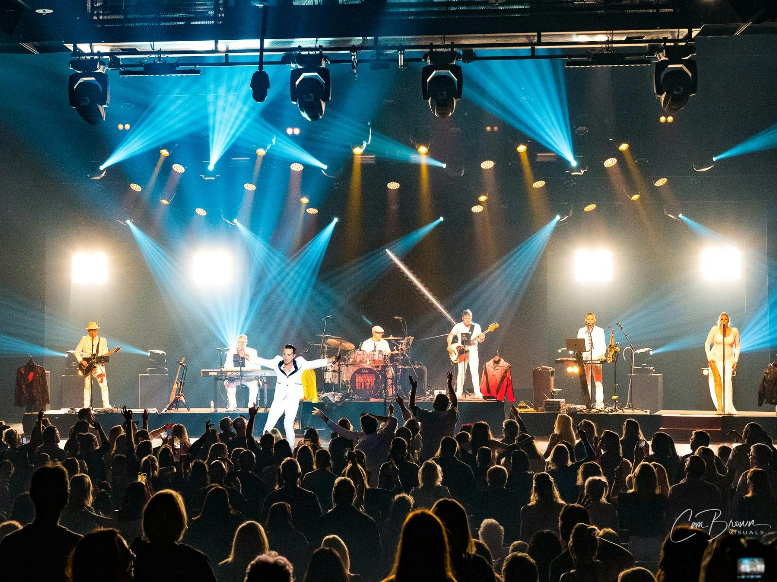 Jason Singh on stage with full band and audience