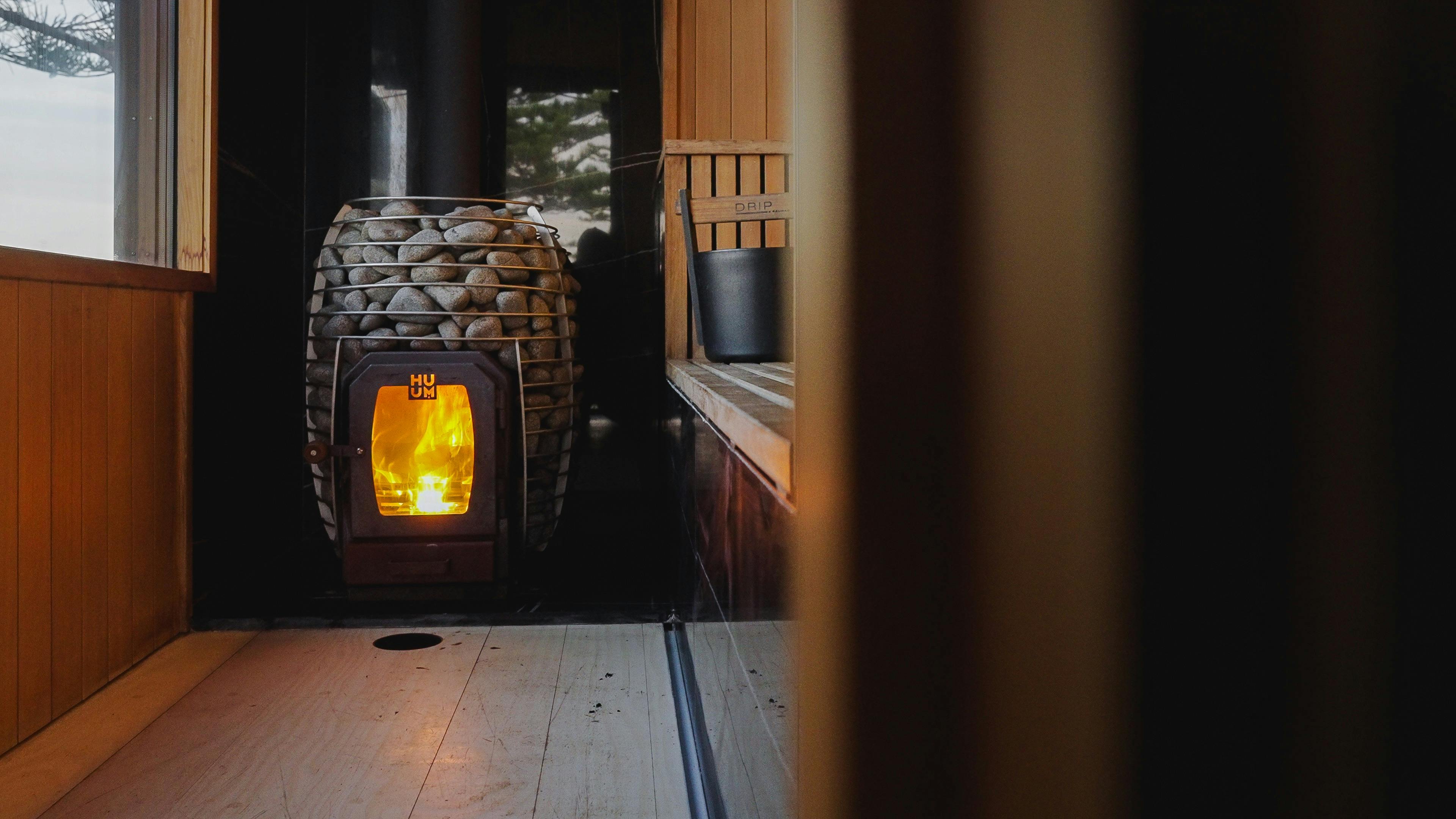 Sauna stones surround a fire box in a timber lined sauna.