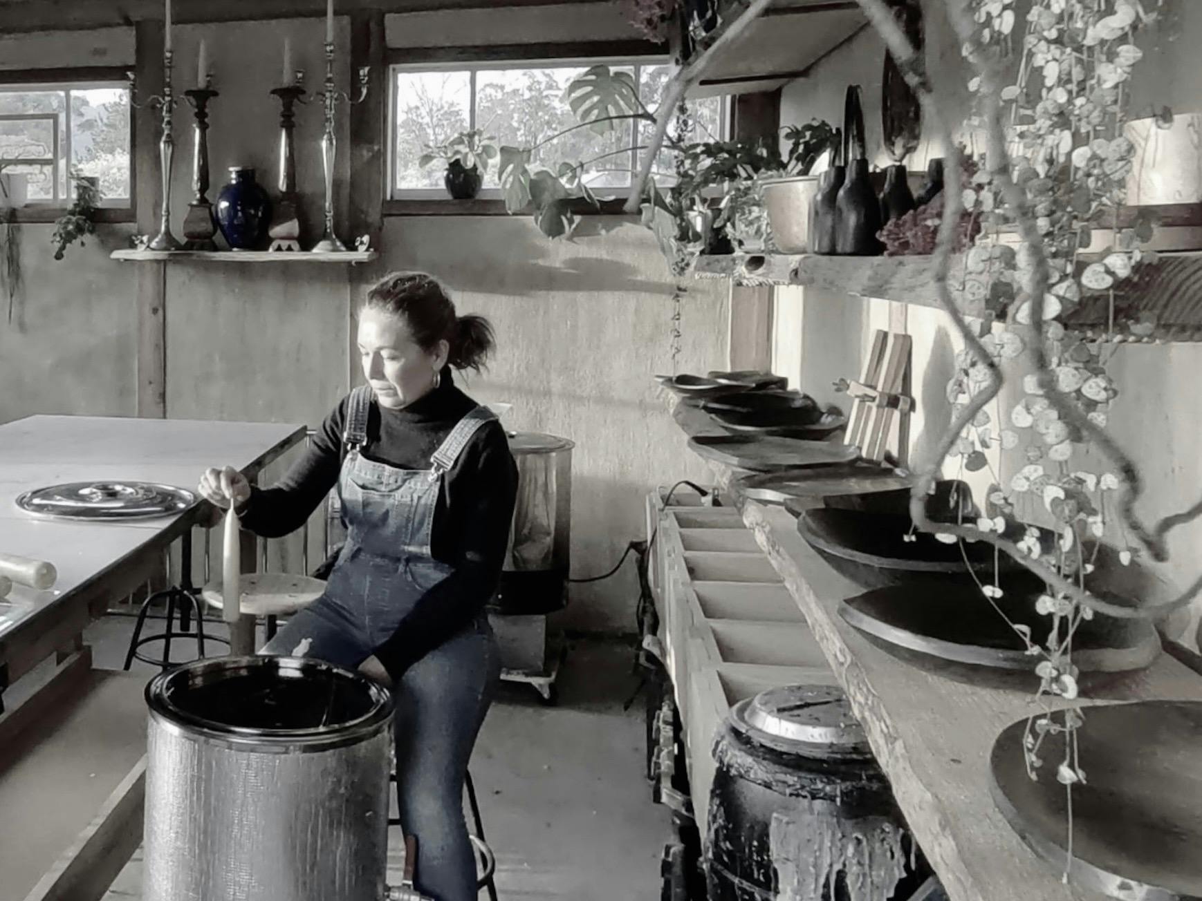 Artist sits in a studio making candles