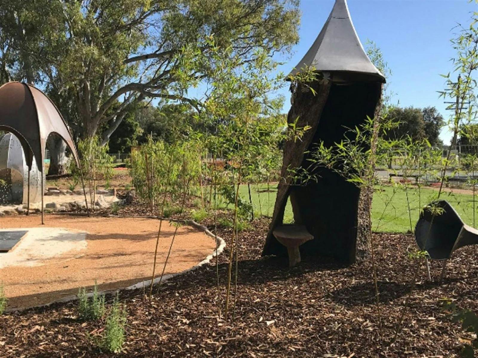 Childrens garden, metal shade, pathway, leaves, sculptures, trees, grass, seat, sculpture, sunshine