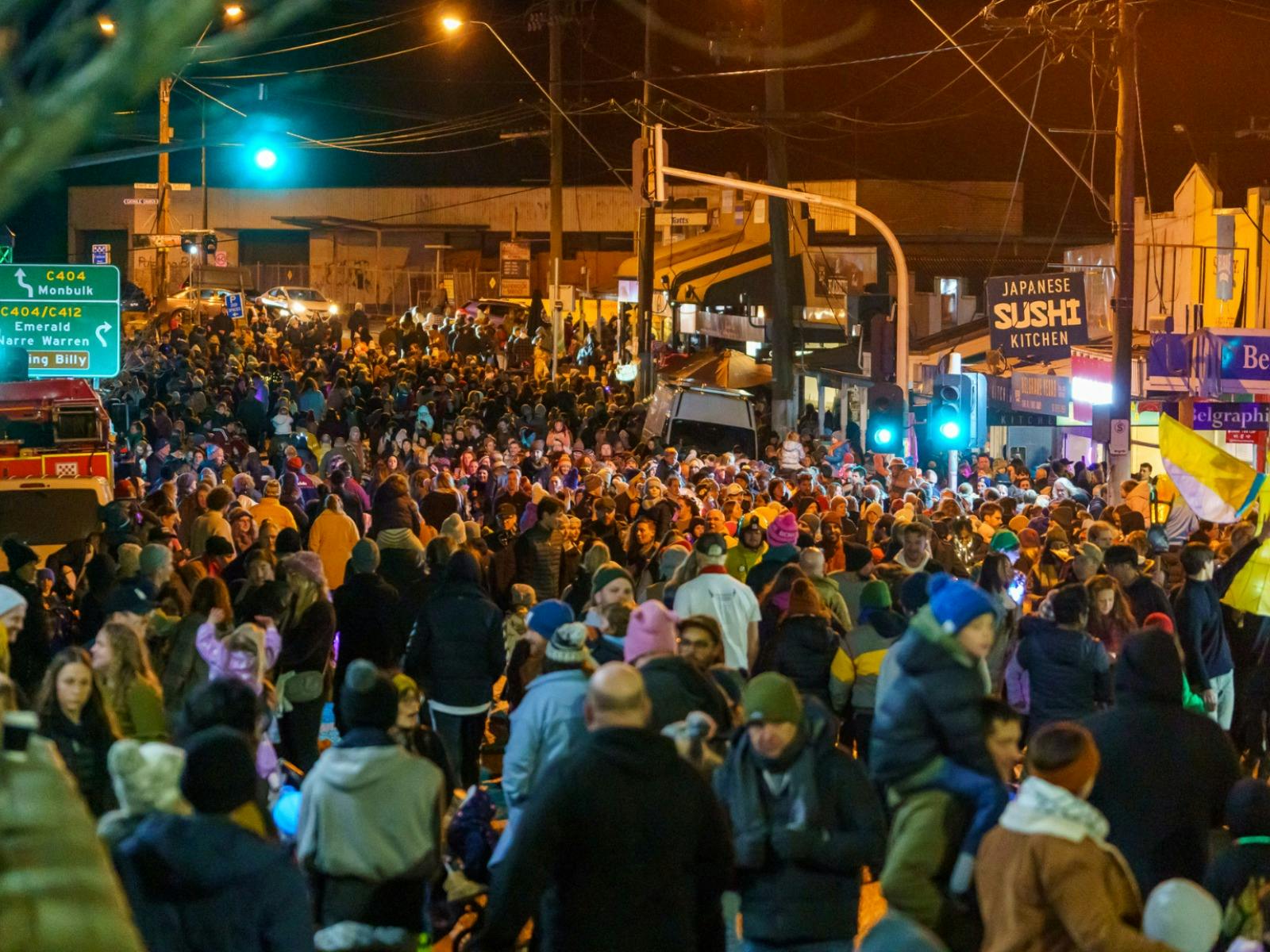 a large crowd of locals gather to watch the belgrave lantern parade