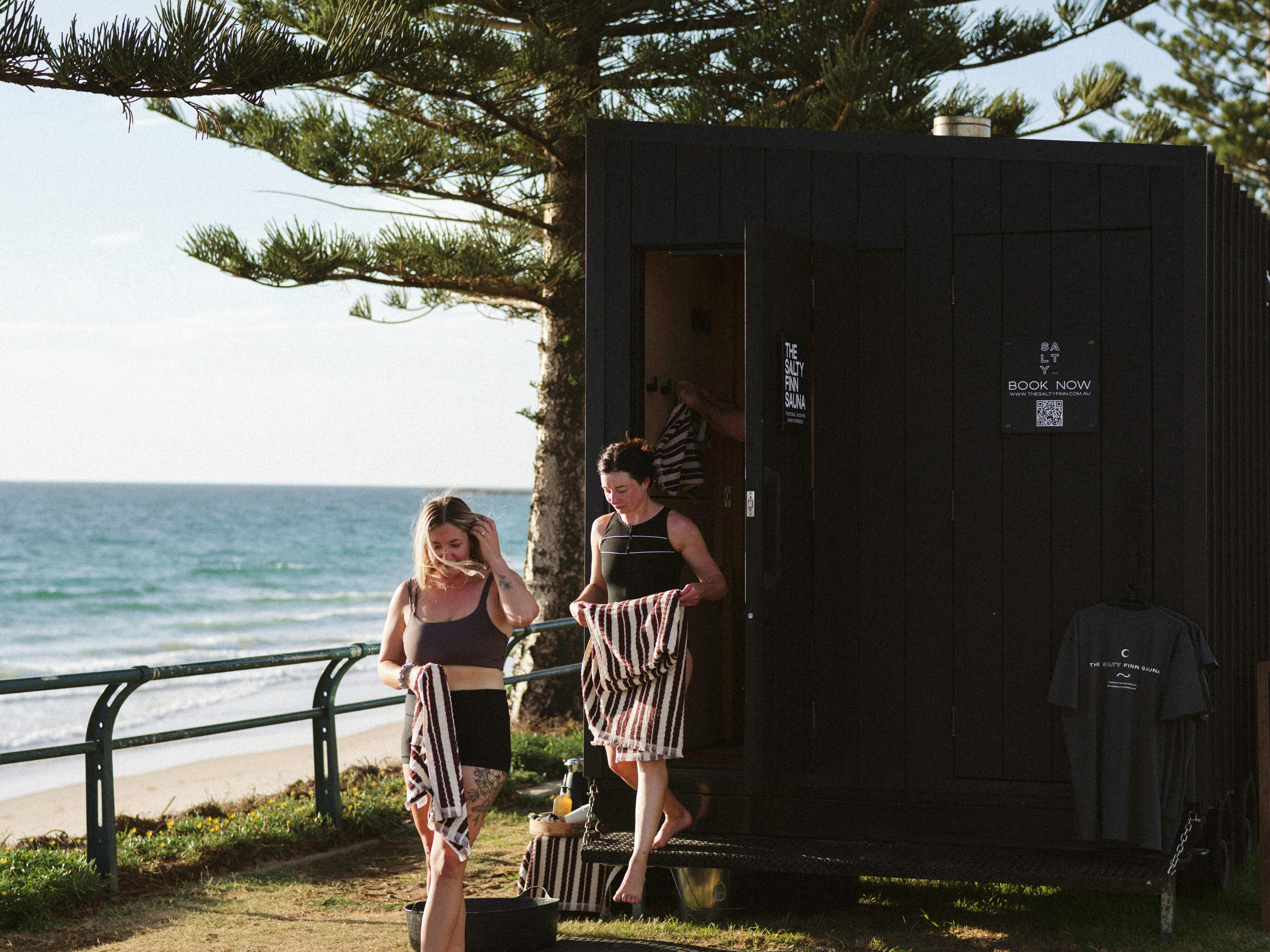 Bathers exit the mobile sauna ready to cool off with an ocean dip