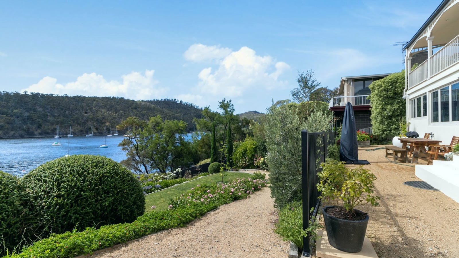 The backyard with picnic table and chairs as well as a BBQ