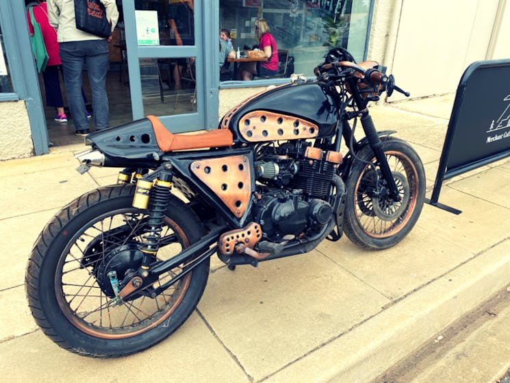 Back and copper coloured motorbike at front entrance