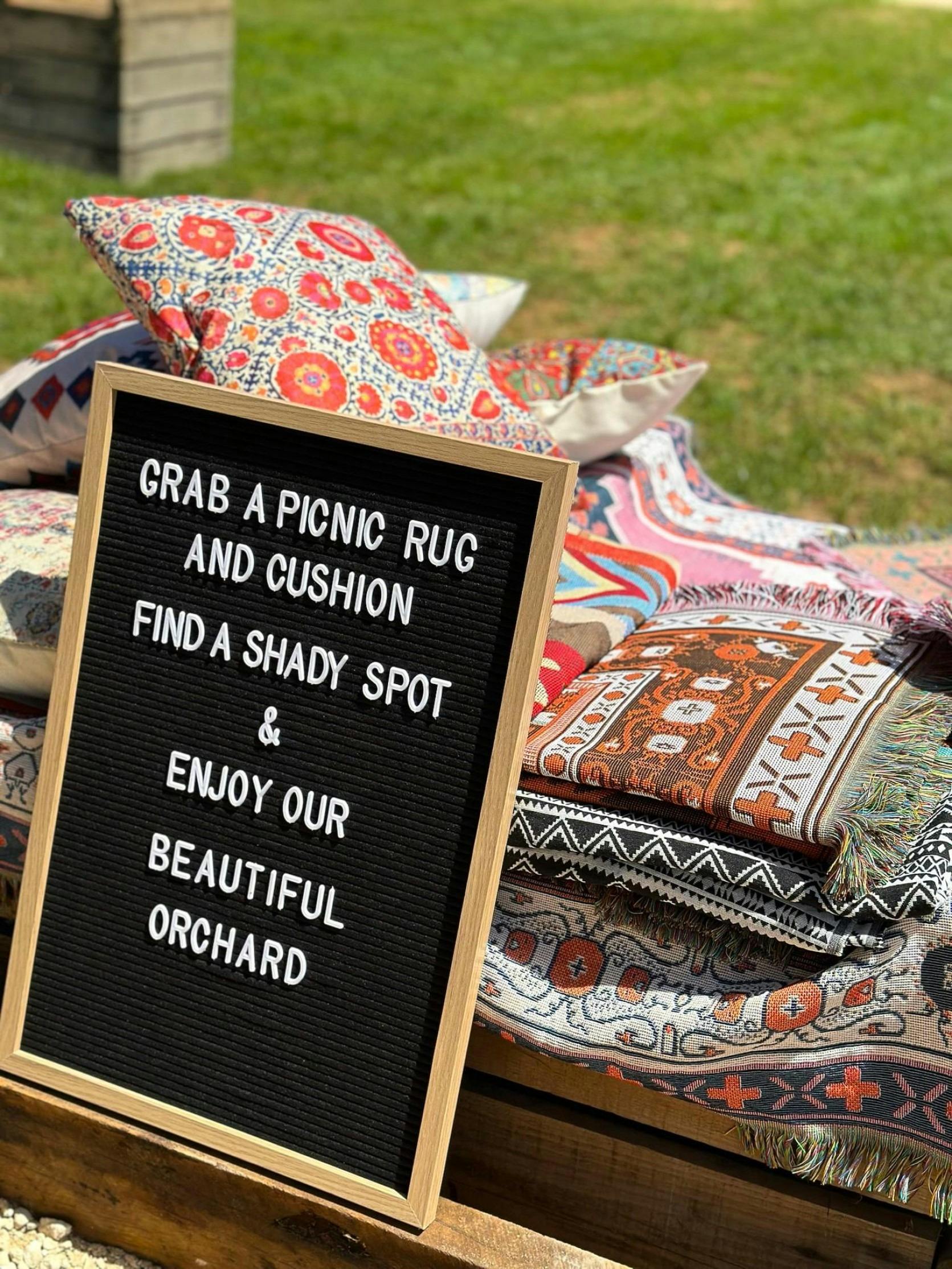 An invitation to enjoy the orchard with rugs and cushions