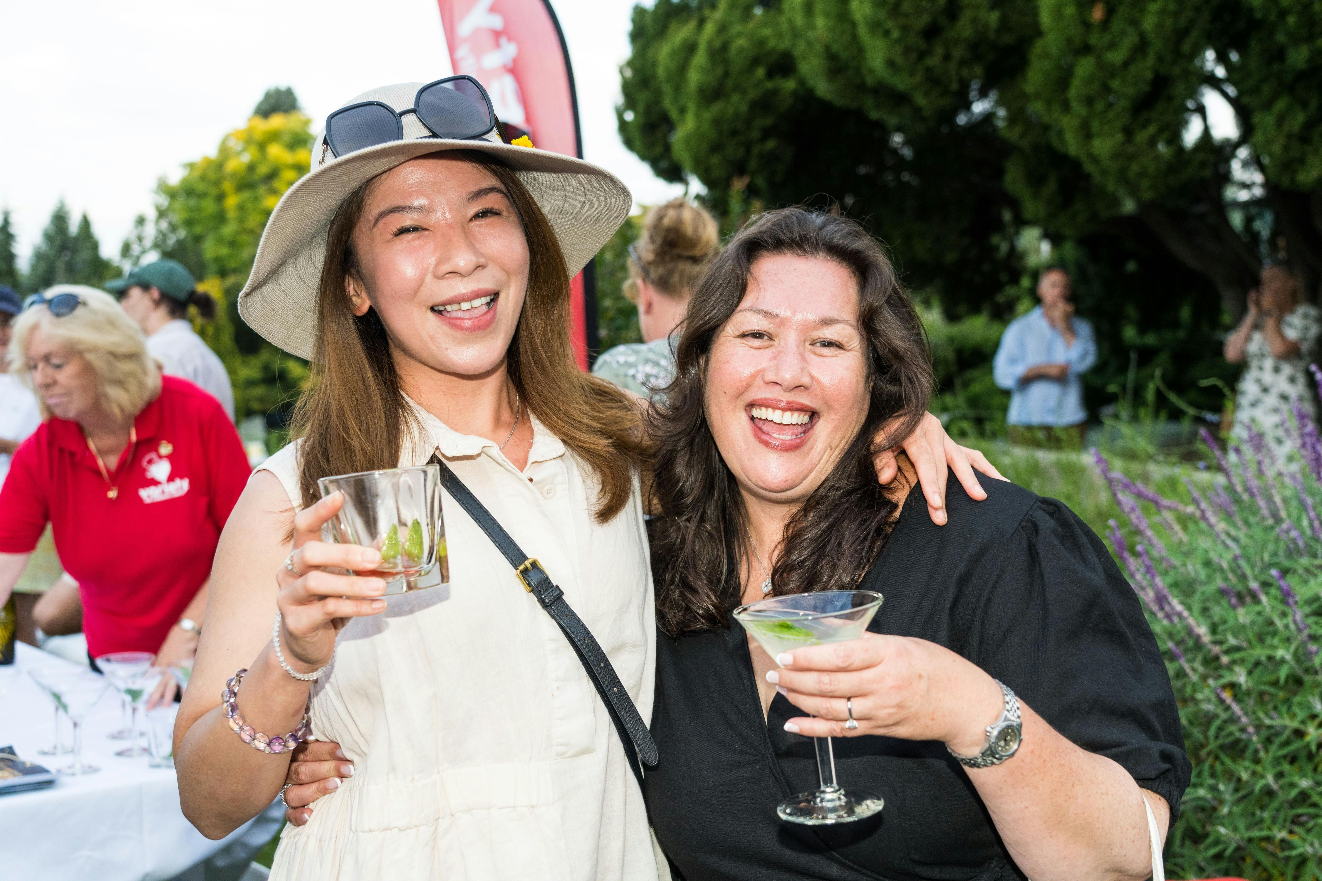 two women with big smiles enjoying gin cocktails