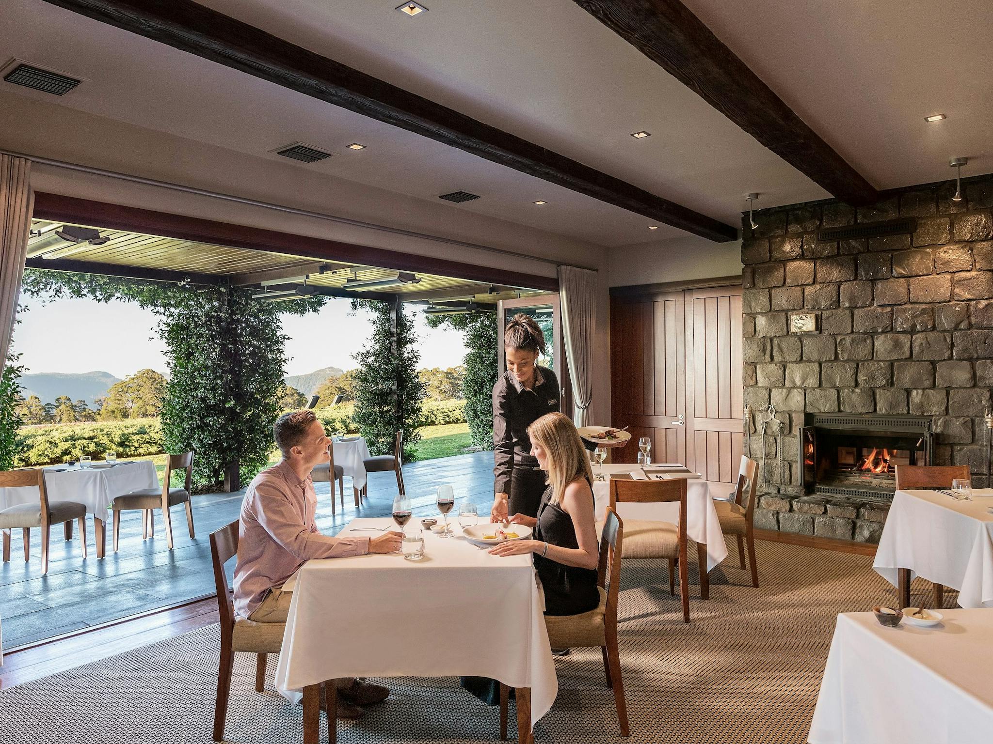 A couple dining at The Peak as a waittress serves them A couple dining at The Peak as a waittress serves them