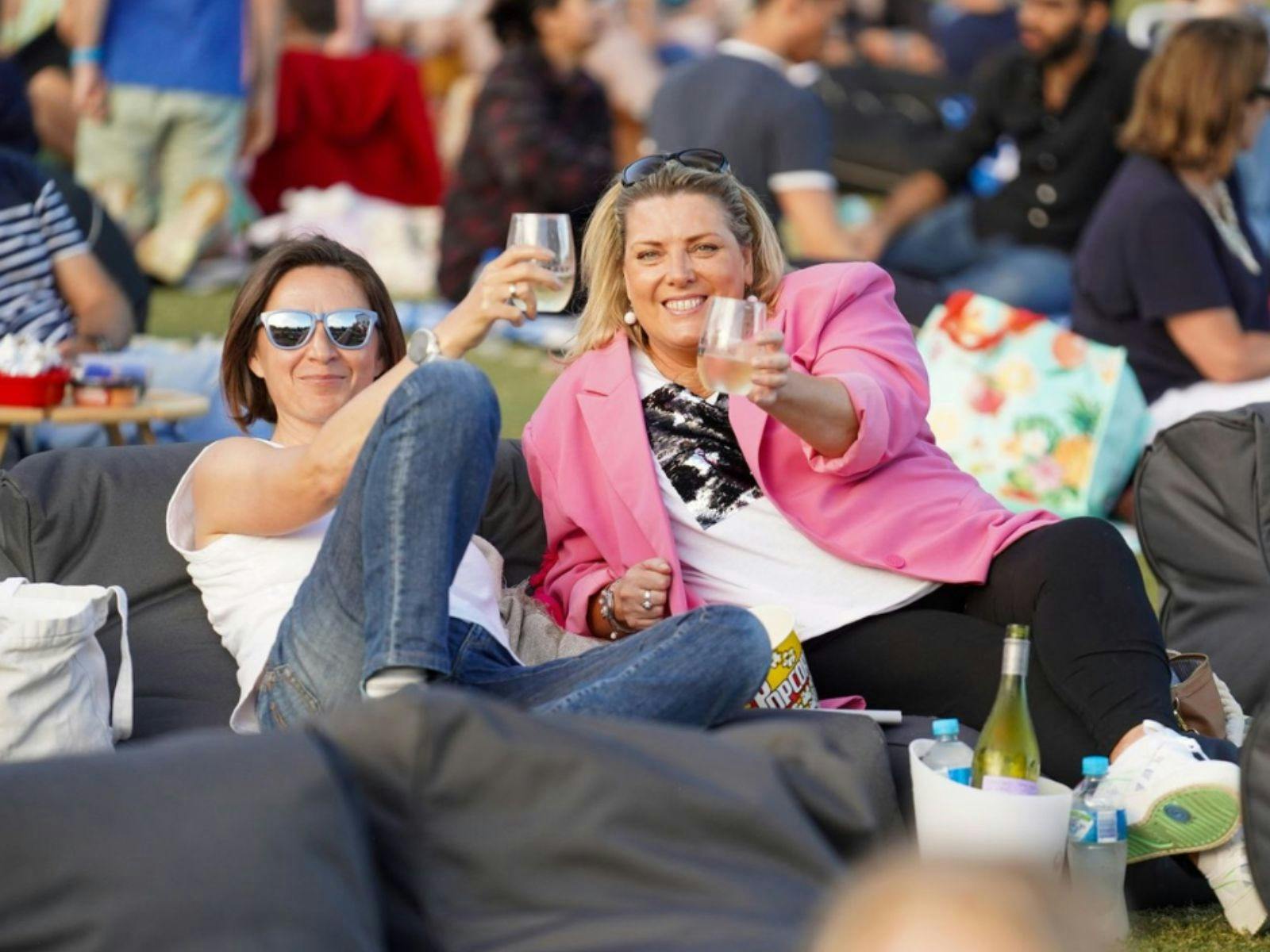 Two friends holding glasses in the Sunset Lounge at Sunset Cinema