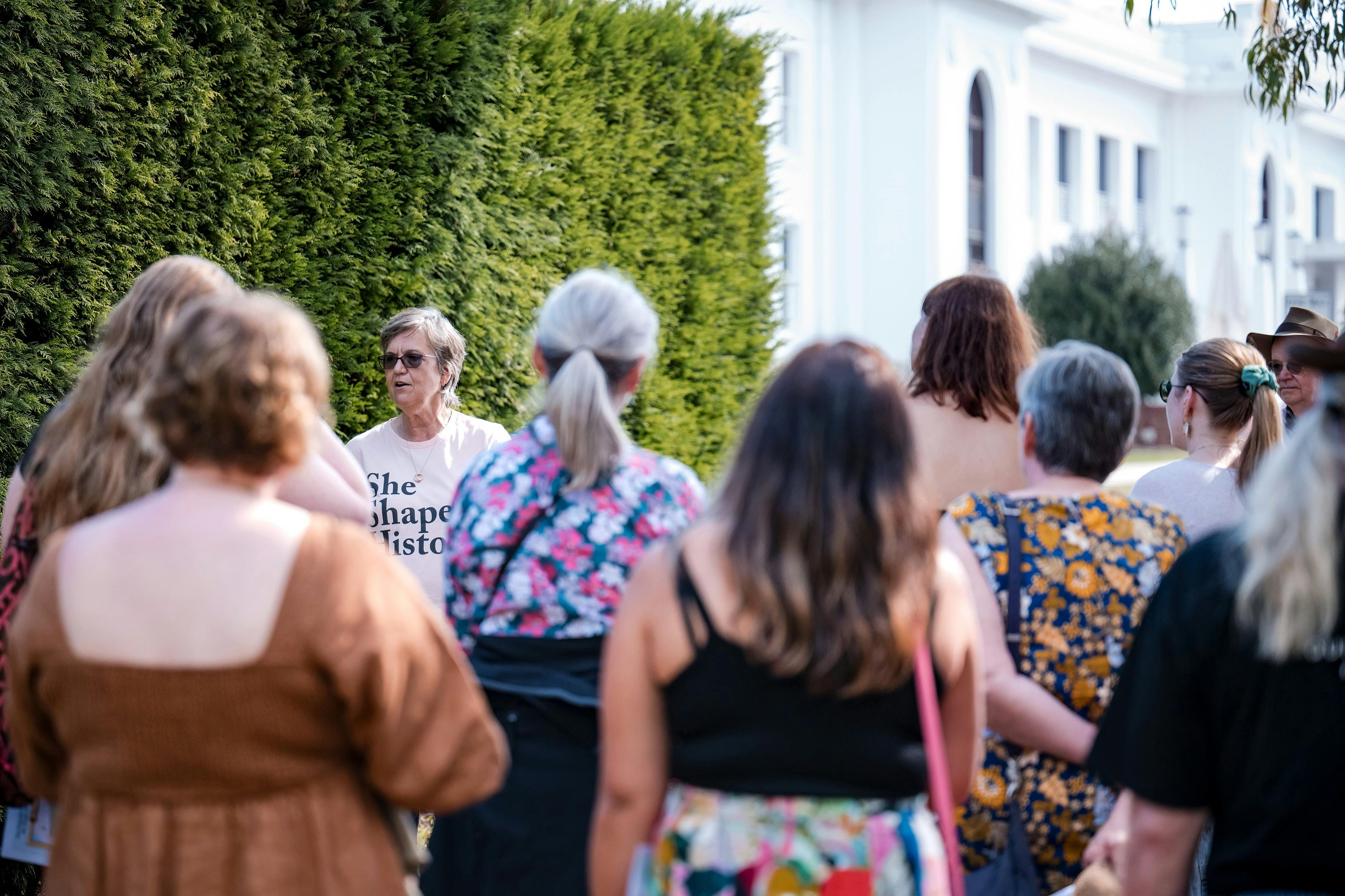 She Shapes History tour guide presenting to the group of engaged guests