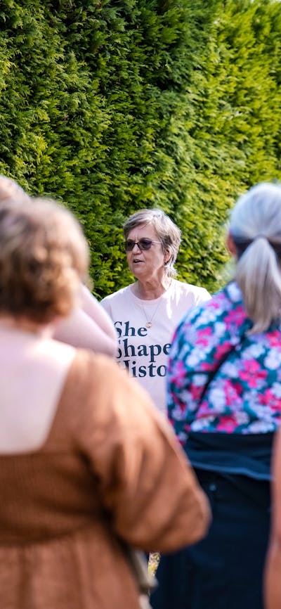 She Shapes History tour guide presenting to the group of engaged guests
