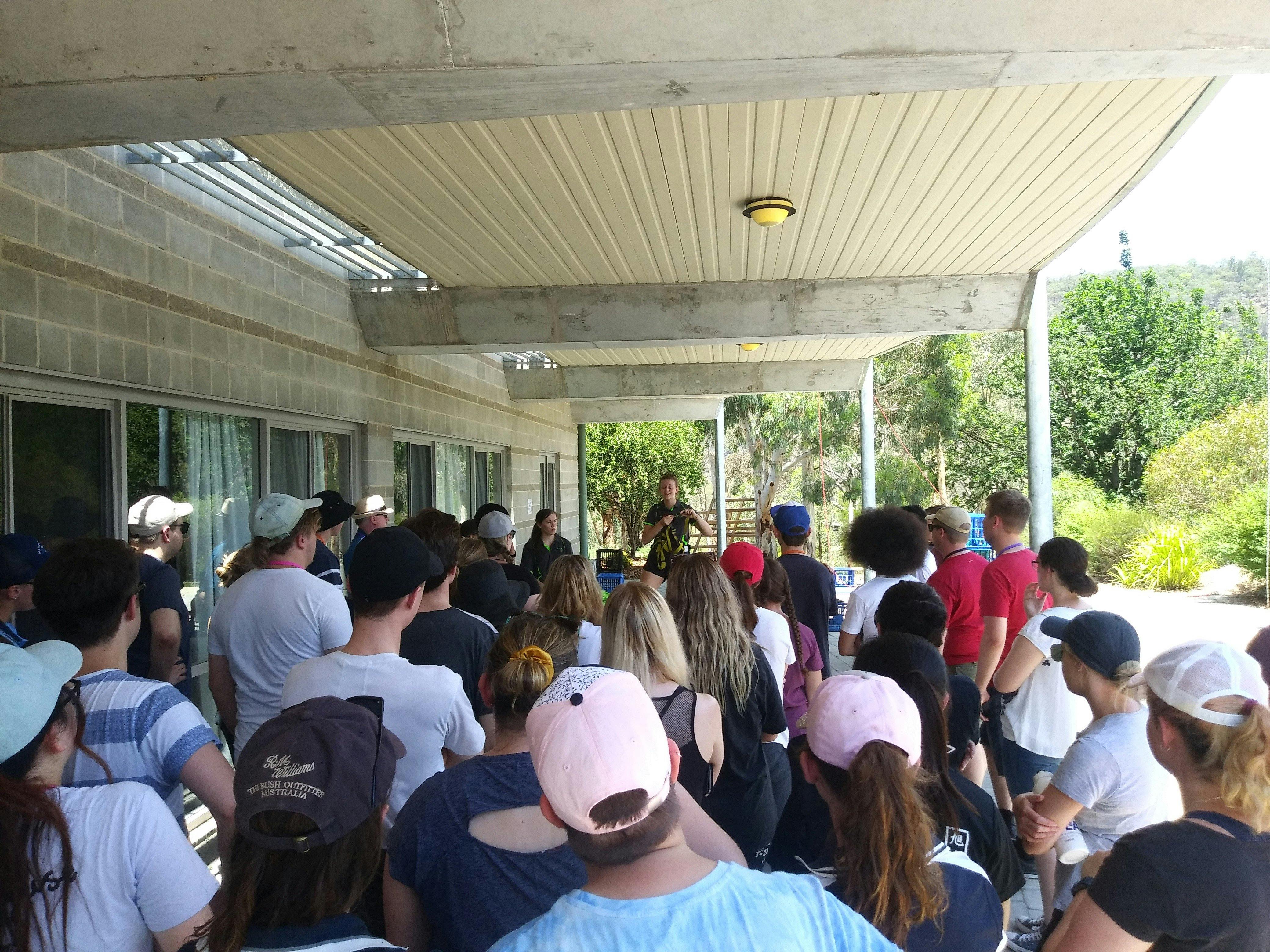 students watching team leader during safety briefing for crate climbing
