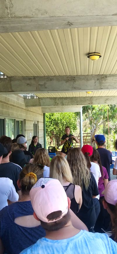 students watching team leader during safety briefing for crate climbing