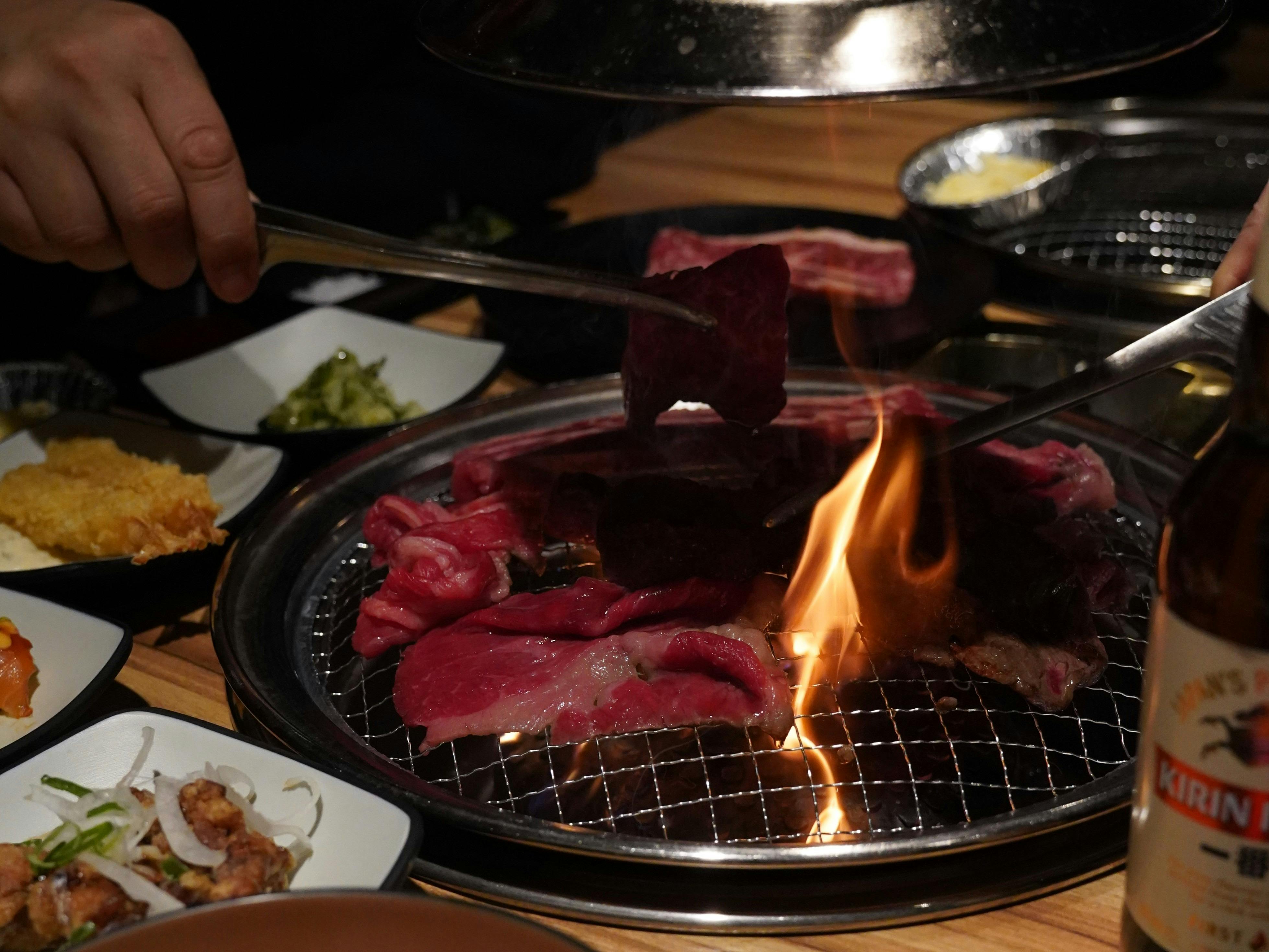 Japanese BBQ meat cooking on a table-top grill at Gyuniku Buffet