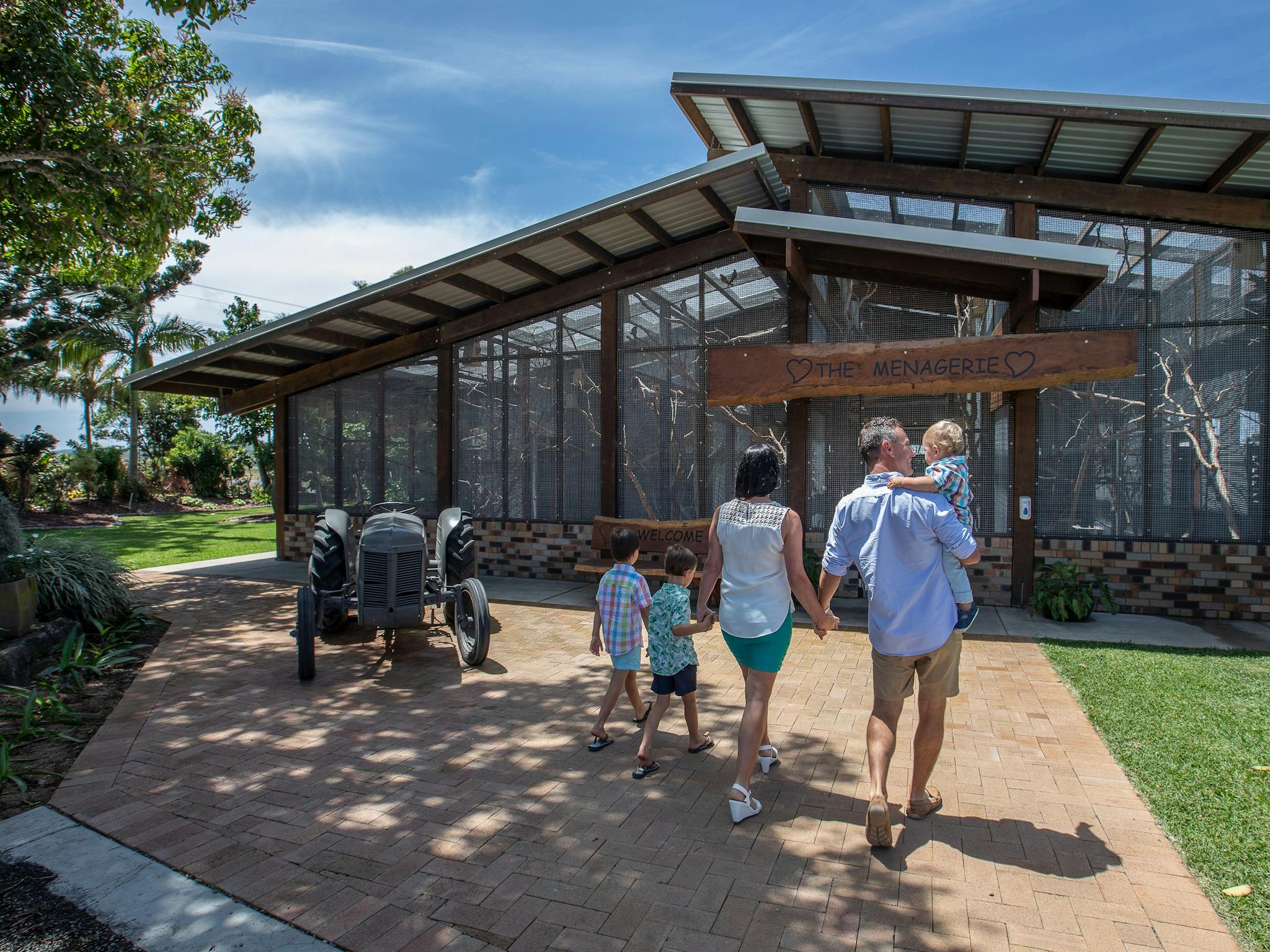 Family walking towards a large bird aviary